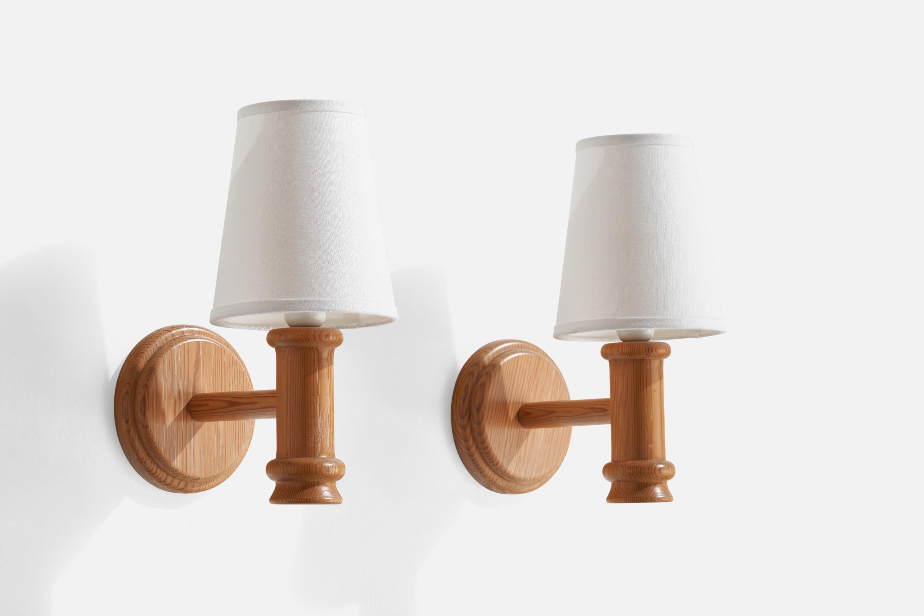 A pair of pine and white fabric wall lights designed and produced in Sweden, 1970s.

Overall Dimensions (inches): 13” H x 6.75” W x 9.75” D
Back Plate Dimensions (inches): n/a
Bulb Specifications: E-26 Bulb
Number of Sockets: 2
All lighting will be