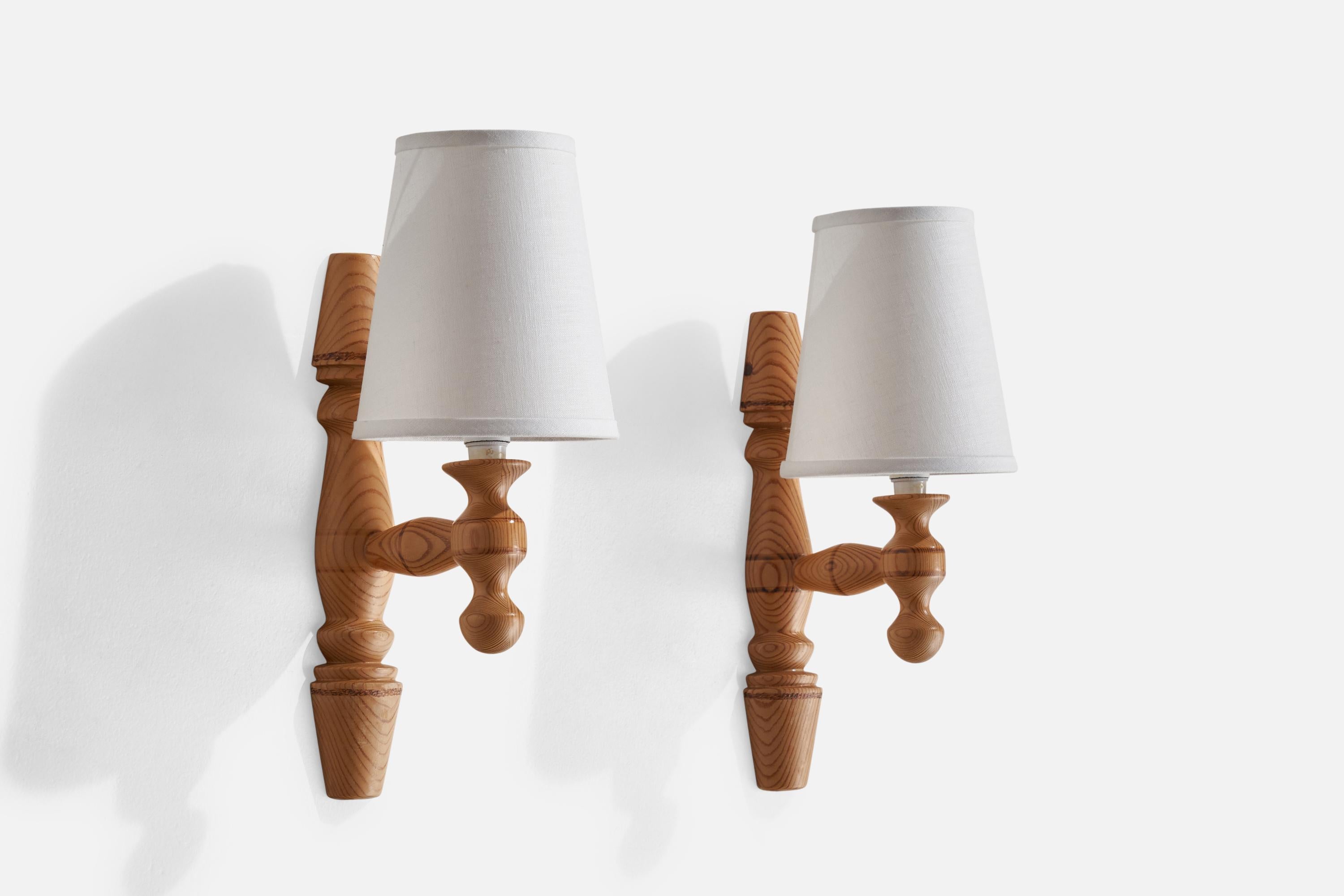 A pair of pine and fabric wall lights designed and produced in Sweden, 1970s.

Overall Dimensions (inches): 13.2” H x 2.5” W x 6.1” D
Back Plate Dimensions (inches): n/a
Bulb Specifications: E-14 Bulbs
Number of Sockets: 2
All lighting will be