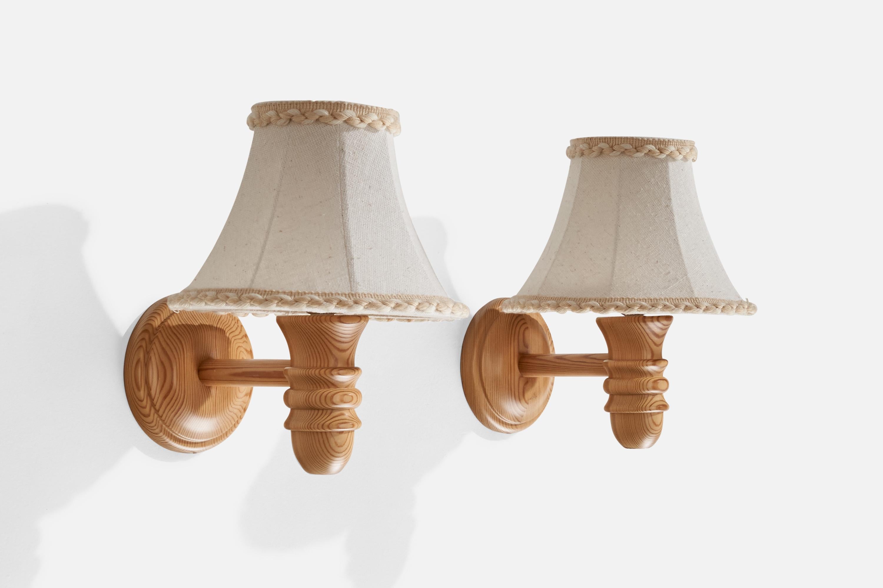 A pair of pine and cream white fabric wall lights designed and produced in Sweden, c. 1970s.

Overall Dimensions (inches): 11” H x 9.875” W x 11.5” D
Back Plate Dimensions (inches): 5.75” H x 1.26” D
Bulb Specifications: E-26 Bulb
Number of Sockets:
