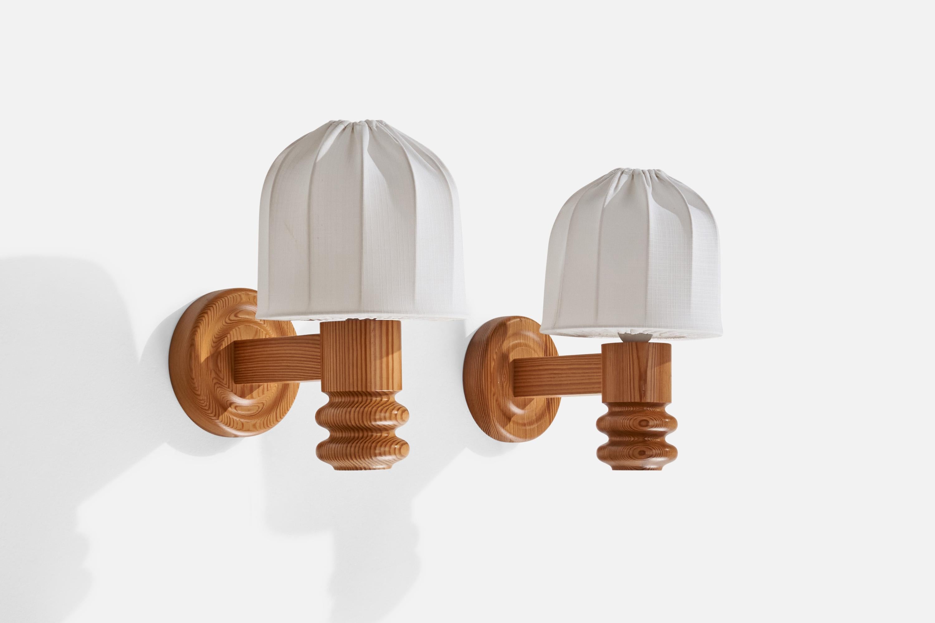 A pair of pine and white fabric wall lights designed and produced in Sweden,  c.1970s.

Overall Dimensions (inches): 12” H x 7.25” W x 10.25” D
Back Plate Dimensions (inches): 5.22” H x 1.05” D
Bulb Specifications: E-26 Bulb
Number of Sockets: 2
All