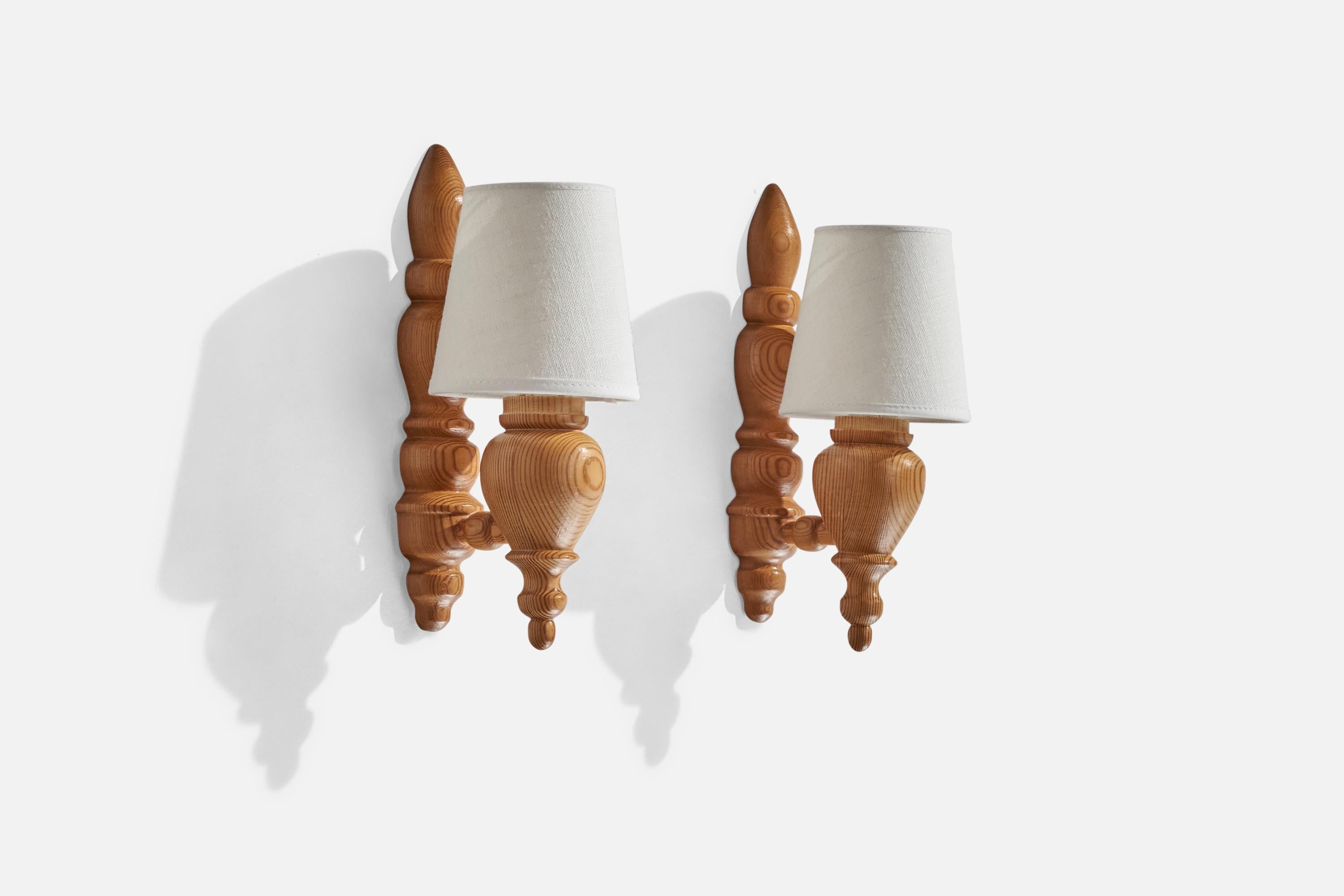 A pair of pine and white fabric wall lights designed and produced in Sweden, c. 1970s.

Overall Dimensions (inches): 9.5” H x 3.75” W x 4.875” D
Back Plate Dimensions (inches):N/A
Bulb Specifications: E-14 Bulb
Number of Sockets: 2
All lighting will