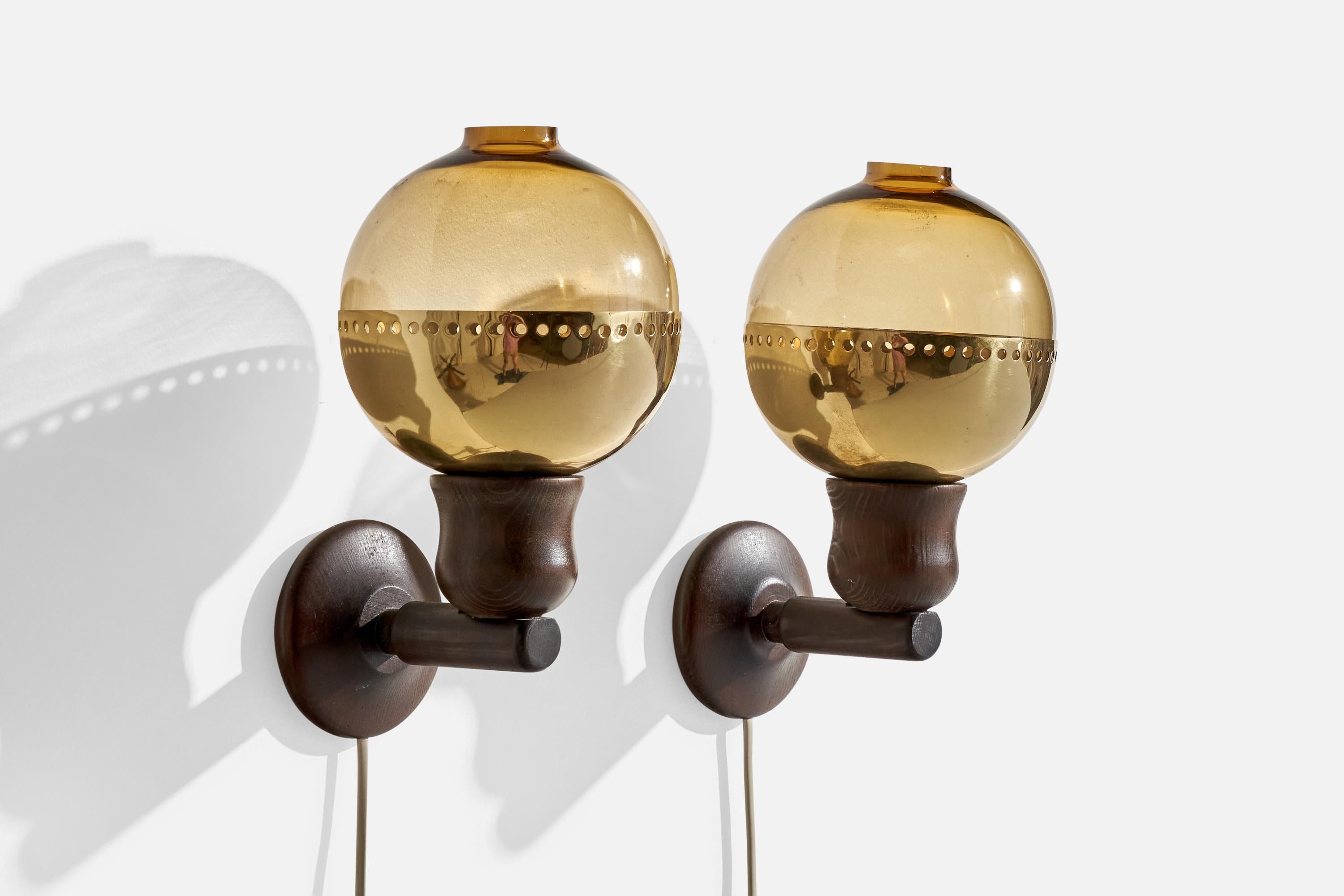 A pair of dark-stained pine, smoked glass and brass wall lights designed and produced in Sweden, c. 1970s.

Assorted vintage brass and glass diffusers

Overall Dimensions (inches):  11” H x  5.875” W x  7“D
Back Plate Dimensions (Inches):  3.75” H x