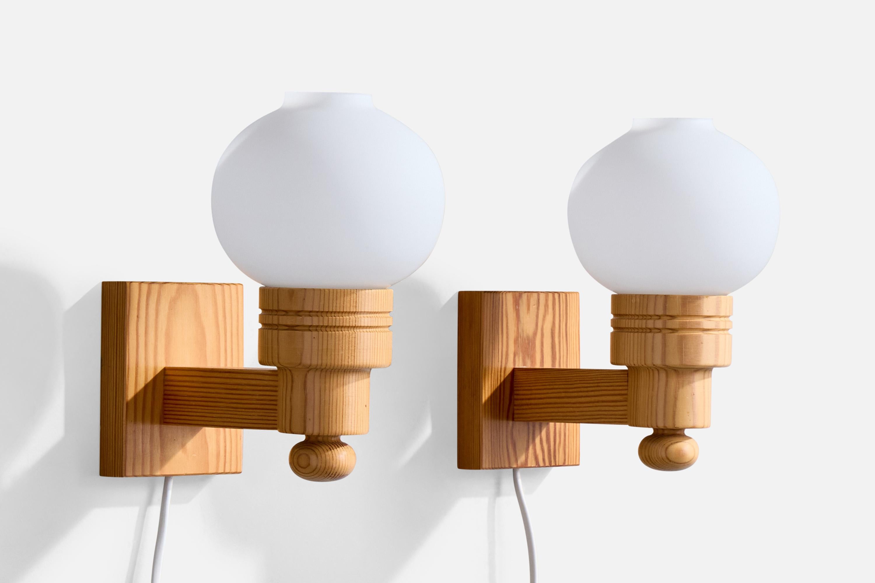 A pair of pine and white opaline glass wall lights designed and produced in Sweden, c. 1970s.

Overall Dimensions (Inches): 8” H x 4.625” W x 7.5“ D

Back Plate Dimensions (Inches): 4.125” H x 3.375“ W x .75” D

Bulb Specifications: E-14

Number of