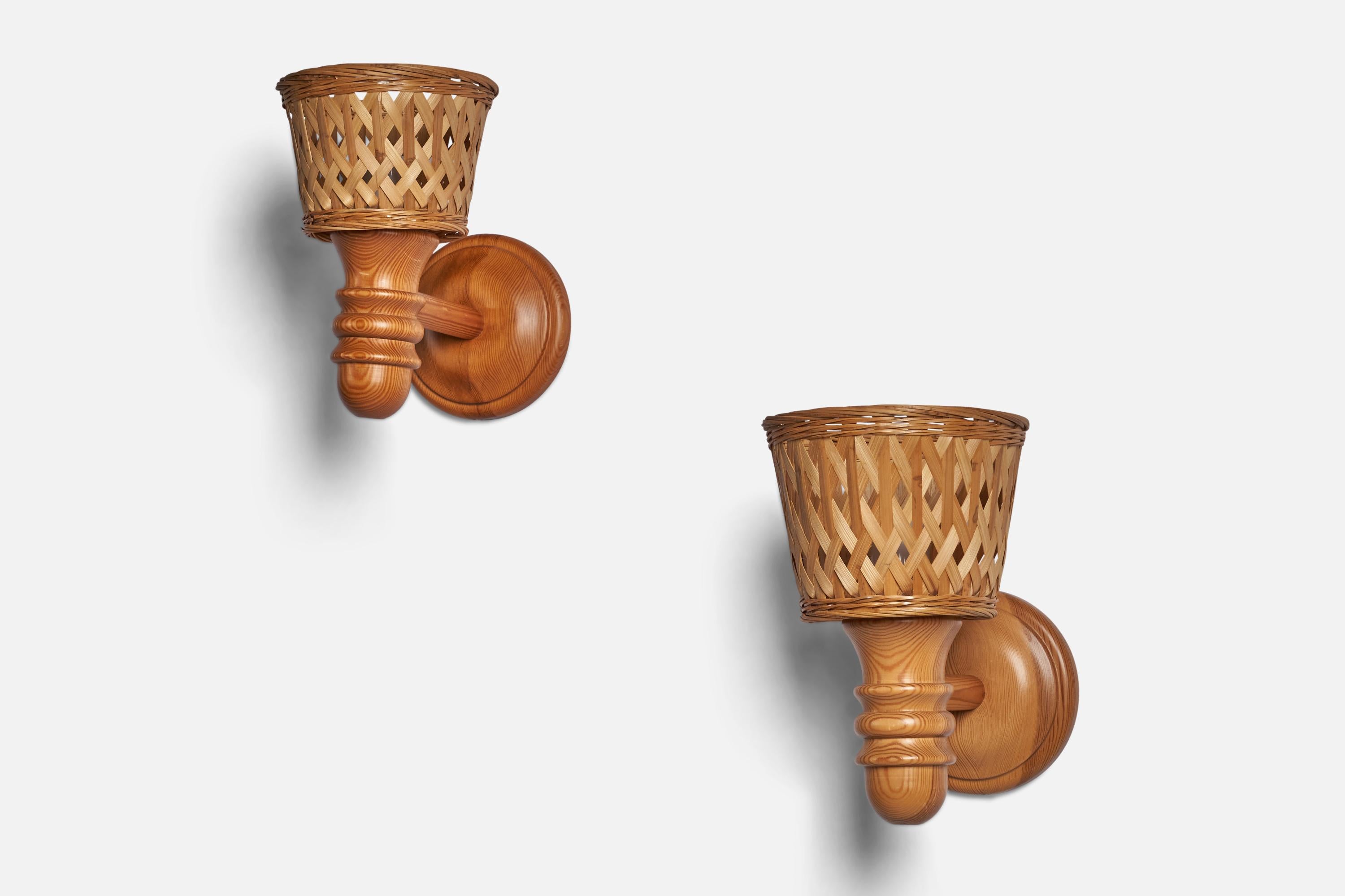 A pair of pine and rattan wall lights designed and produced in Sweden, c. 1970s.

Overall Dimensions (inches): 10” H x 6.25” W x 10” D
Back Plate Dimensions (inches): 5.75” Diameter
Bulb Specifications: E-26 Bulb
Number of Sockets: 1
All lighting