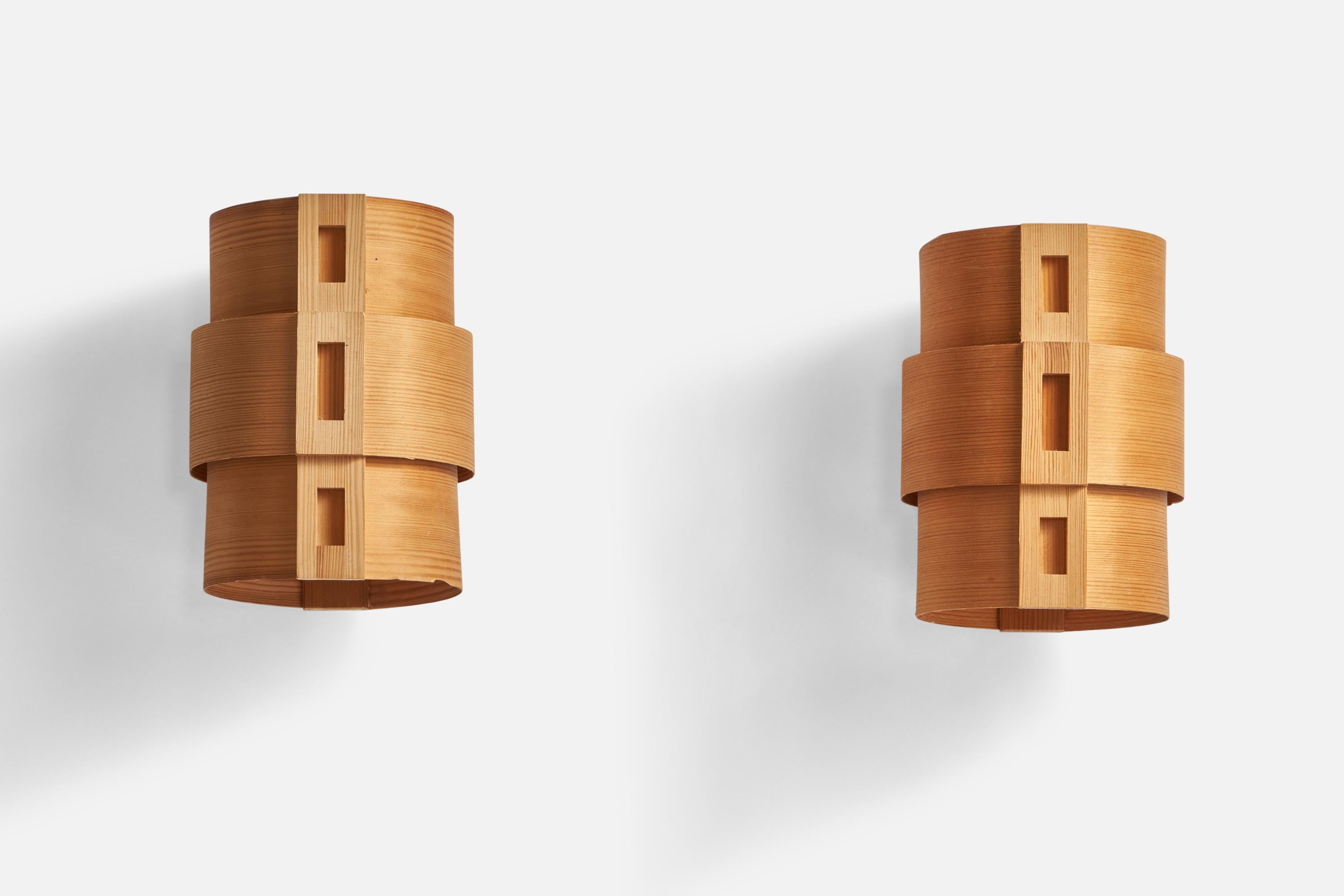 A pair of pine and moulded pine veneer wall lights designed and produced in Sweden, c. 1970s.

Overall Dimensions (inches): 7.5” H x 5.72” Diameter
Back Plate Dimensions (inches): n/a
Bulb Specifications: E-14 Bulbs
Number of Sockets: 2
All lighting