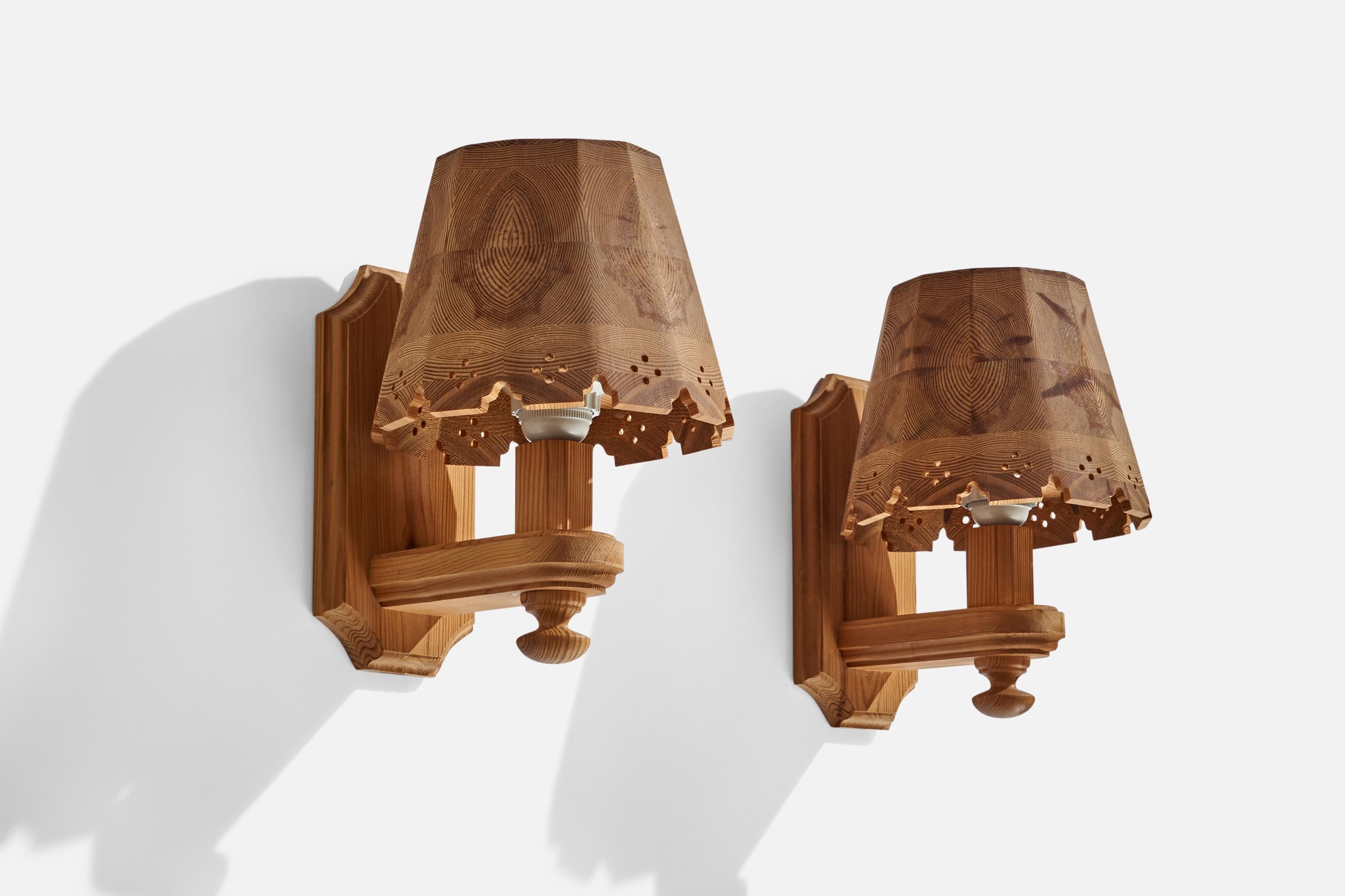 A pair of pine wall lights designed and produced in Sweden, c. 1970s.

Overall Dimensions (inches): 7.75” H x 7.5” W x 10.5” D
Back Plate Dimensions (inches): 9.5” H x 4.25” W x 0.70” D
Bulb Specifications: E-26 Bulb
Number of Sockets: 2
All
