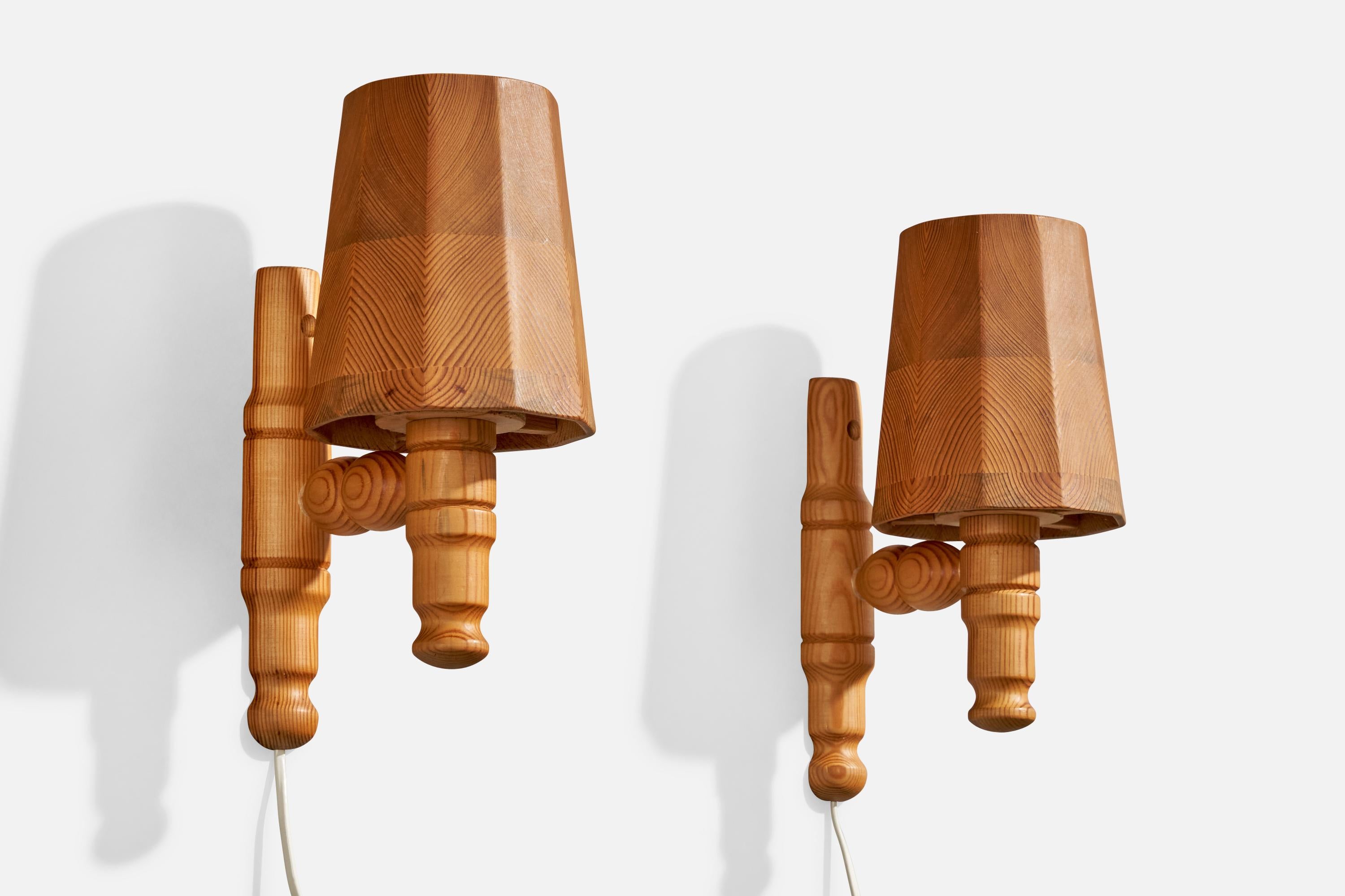 A pair of pine wall lights designed and produced in Sweden, c. 1970s.

Overall Dimensions (inches):  11.5 H x  5.125” W x  7.75“D

Back Plate Dimensions (Inches):  ” H x ” W x ” D

Bulb Specifications: E-14

Number of Sockets (per fixture): 1

Does