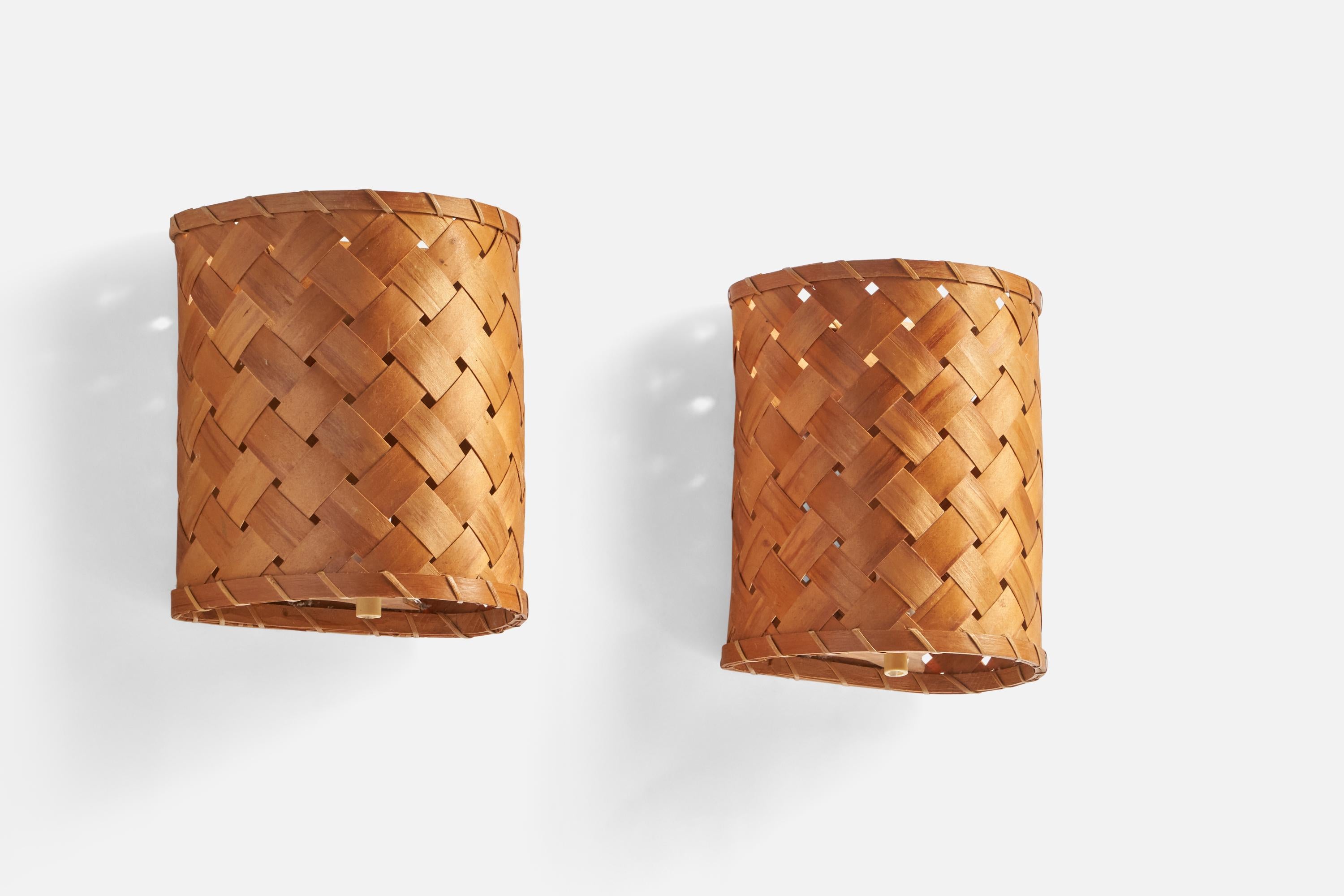 A pair of braided pine veneer wall lights designed and produced in Sweden, c. 1960s.

Overall Dimensions (inches): 8.75” H x 7.5” W x 6” D
Back Plate Dimensions (inches): N/A
Bulb Specifications: E-14 Bulbs
Number of Sockets: 2
All lighting will be