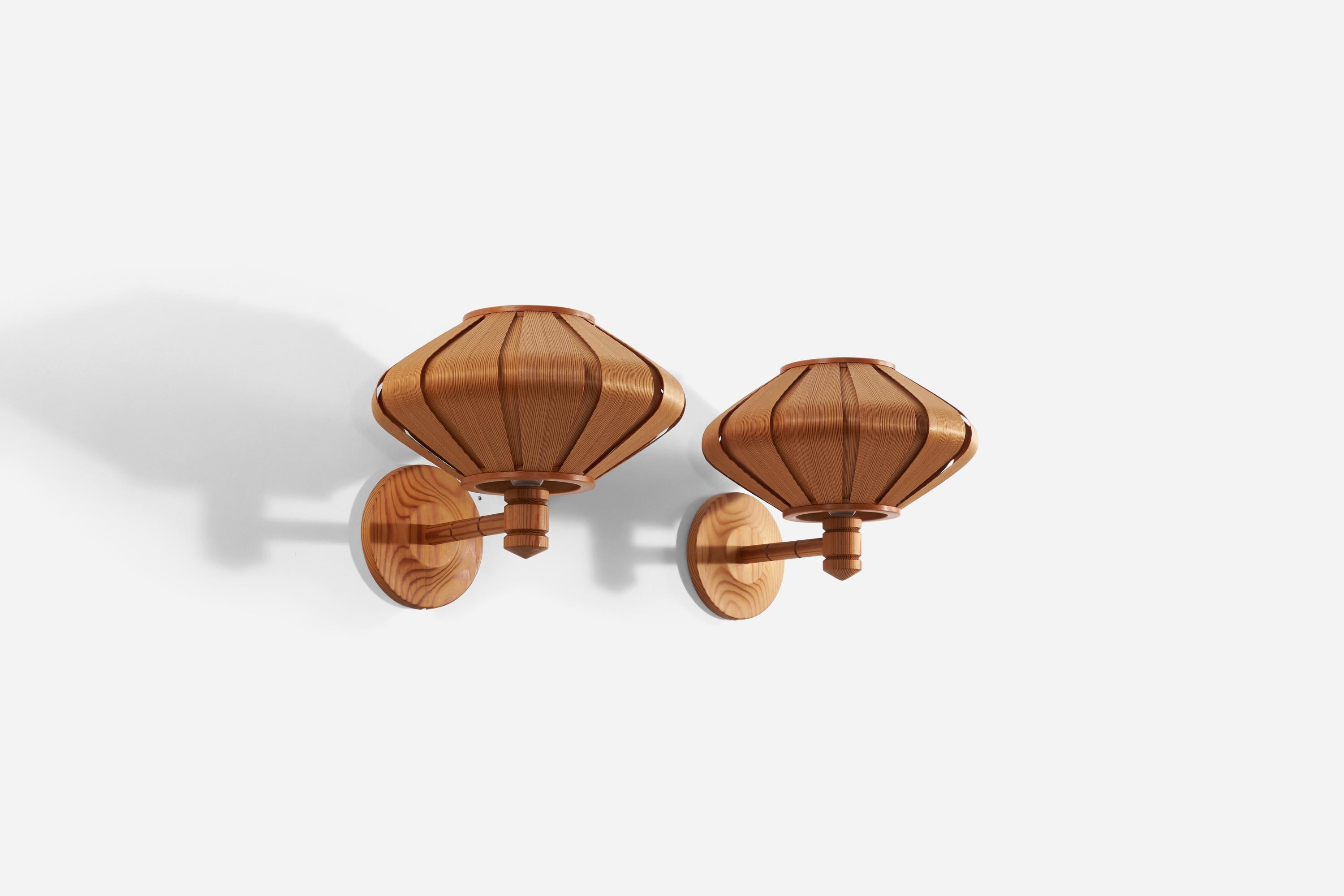 A pair of solid pine and teak veneer wall lights. Designed and produced in Sweden, 1970s.