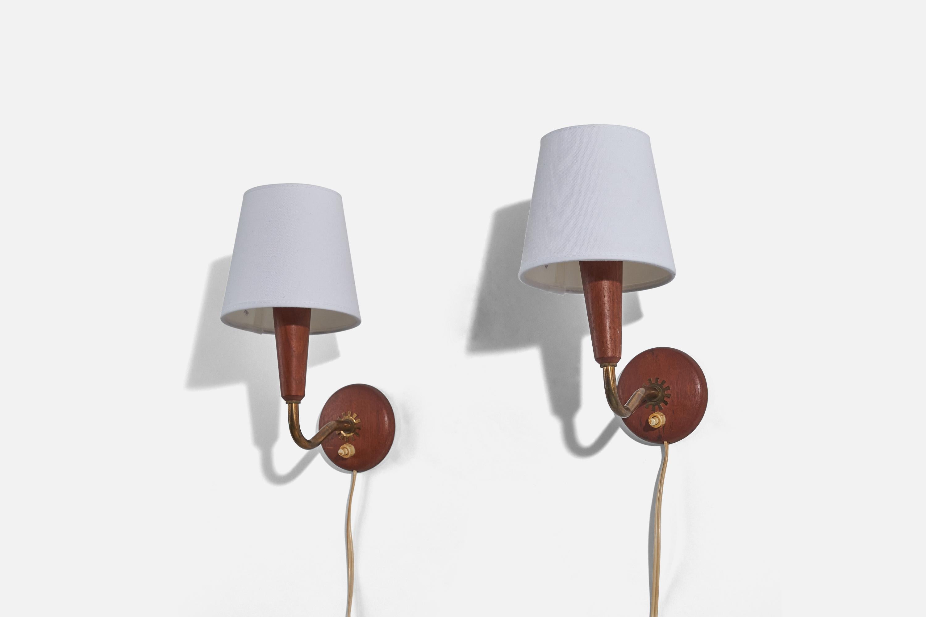 A pair of teak, brass and fabric wall lights designed and produced in Sweden, c. 1950s. 

Sold with lampshades.
Dimensions of Sconce (inches) : 5.875 x 3.125 x 4.6875 (H x W x D)
Dimensions of Shade (inches) : 3.5 x 4.75 x 4.5 (T x B x