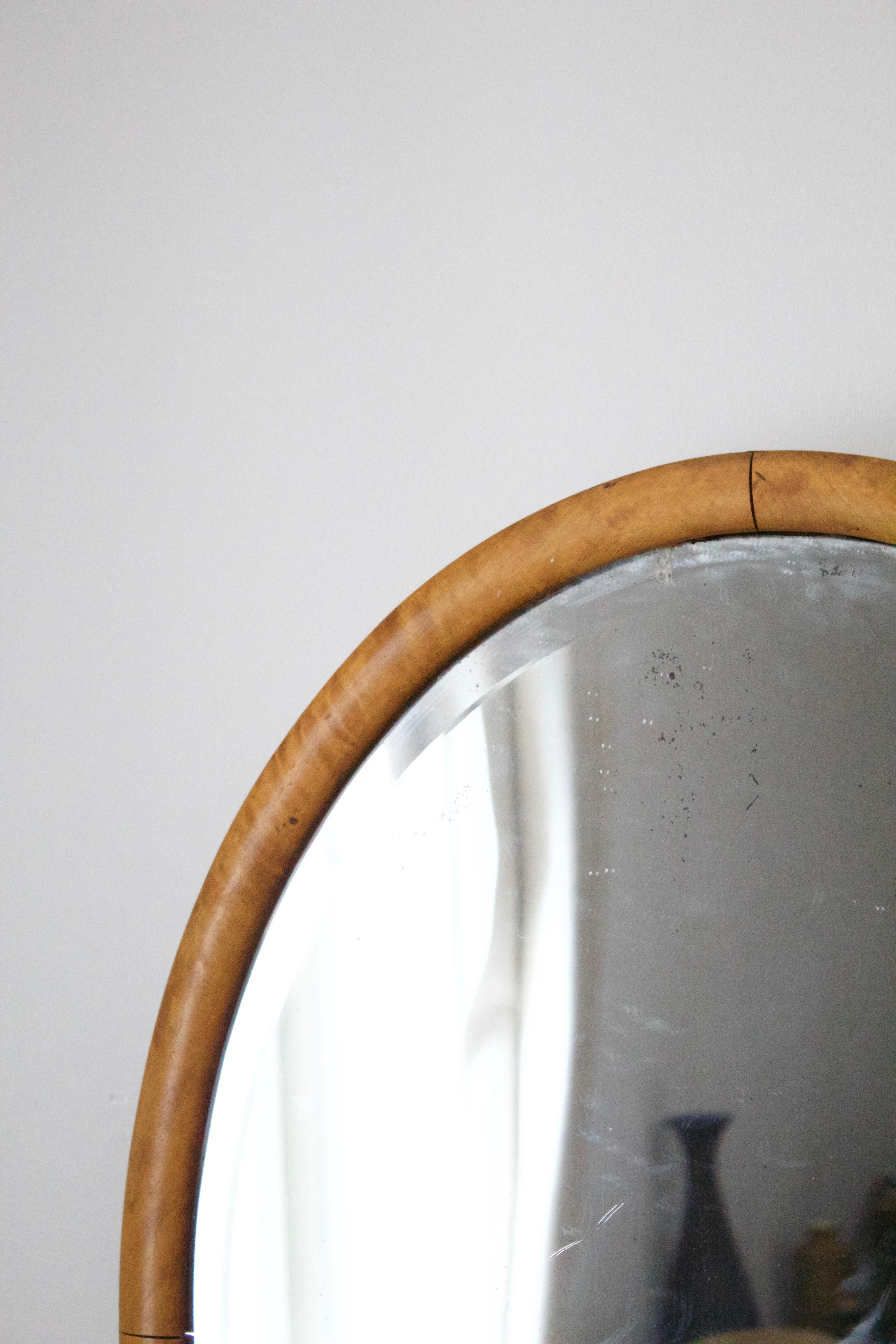 A Swedish wall mirror. Designed and produced in Sweden, 1930s. Features it's original mirror glass and a lacquered burlwood frame.