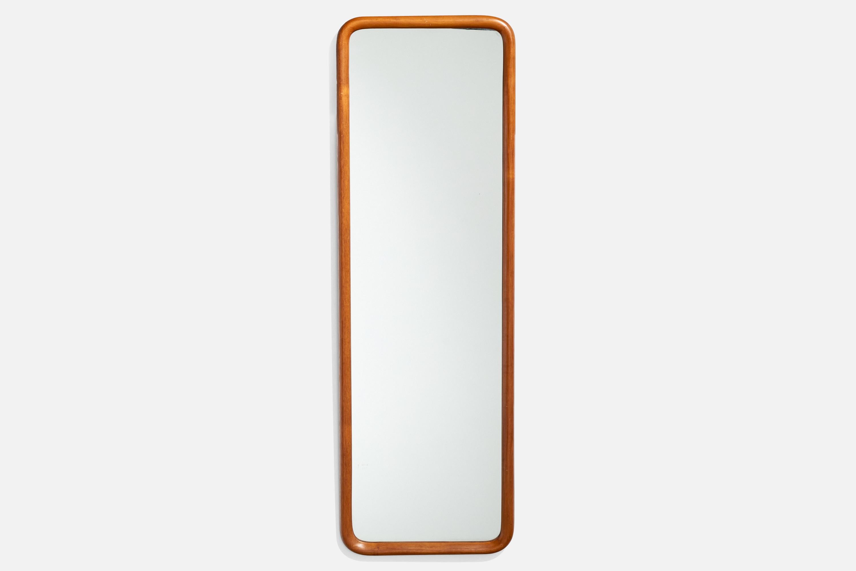 Miroir mural en bois avec détails ornementaux en laiton, conçu et produit en Suède, c. 1950-1960.
