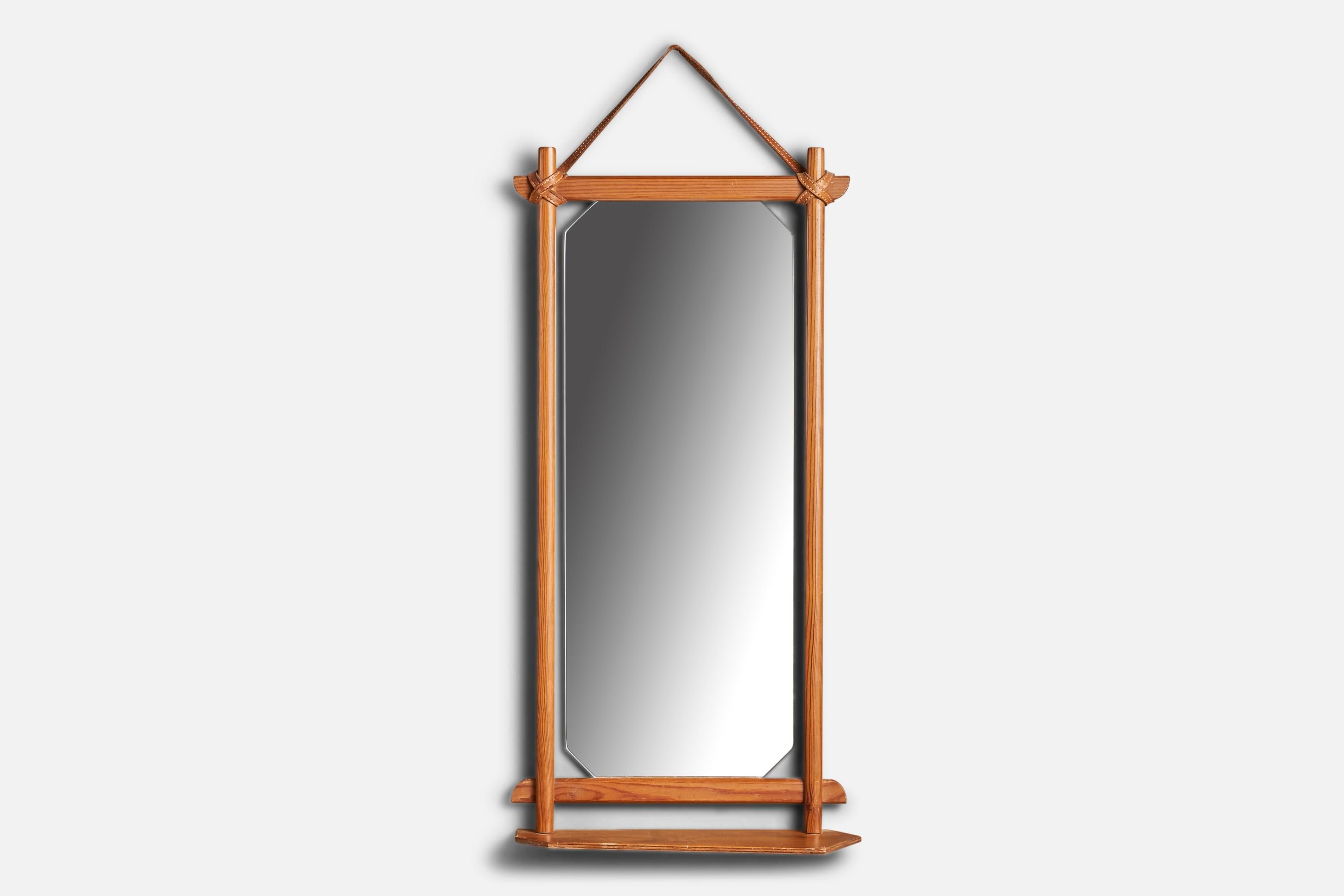 A pine and leather wall mirror designed and produced in Sweden, 1960s.