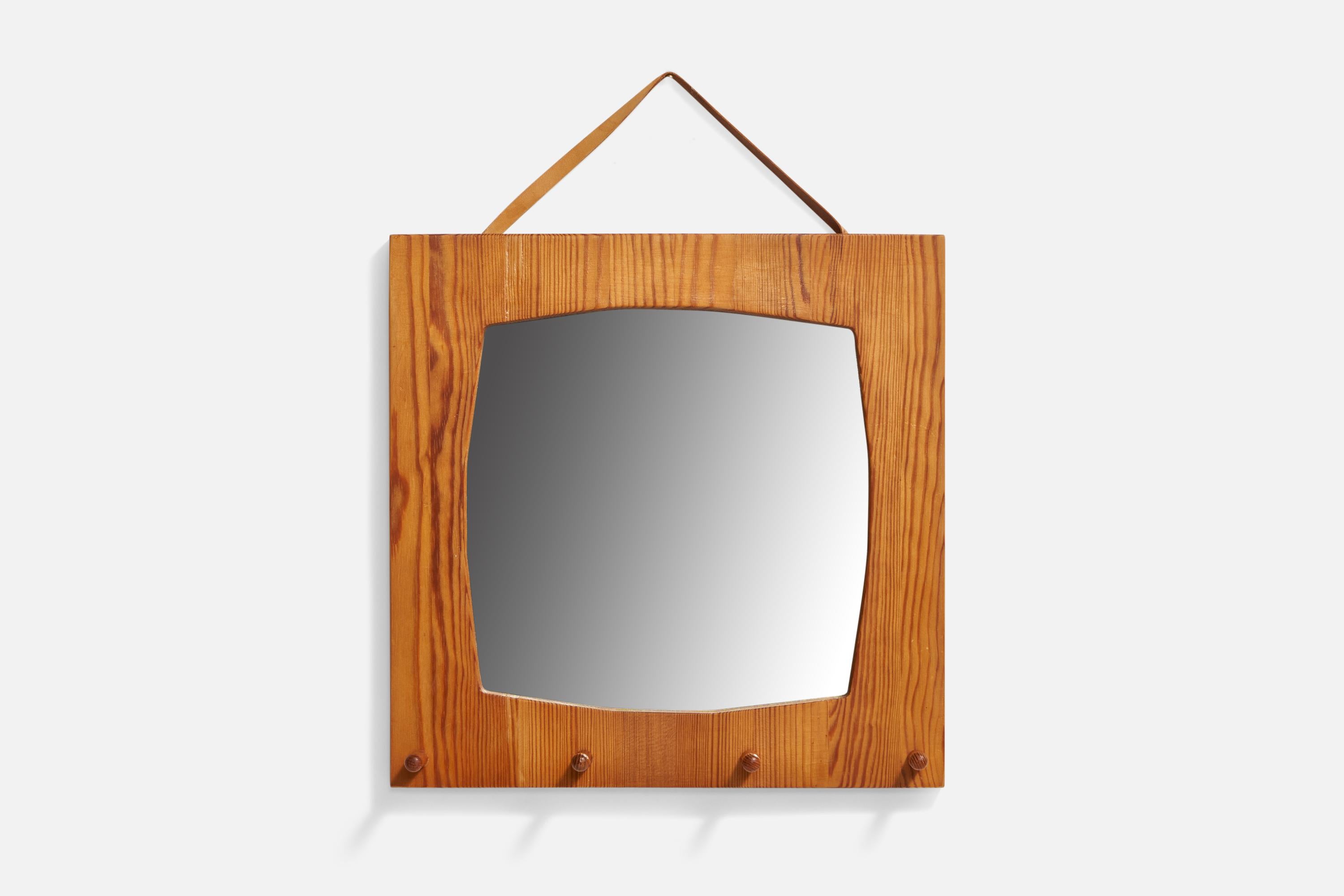 A pine and leather wall mirror with coat rack designed and produced in Sweden, c. 1970s.