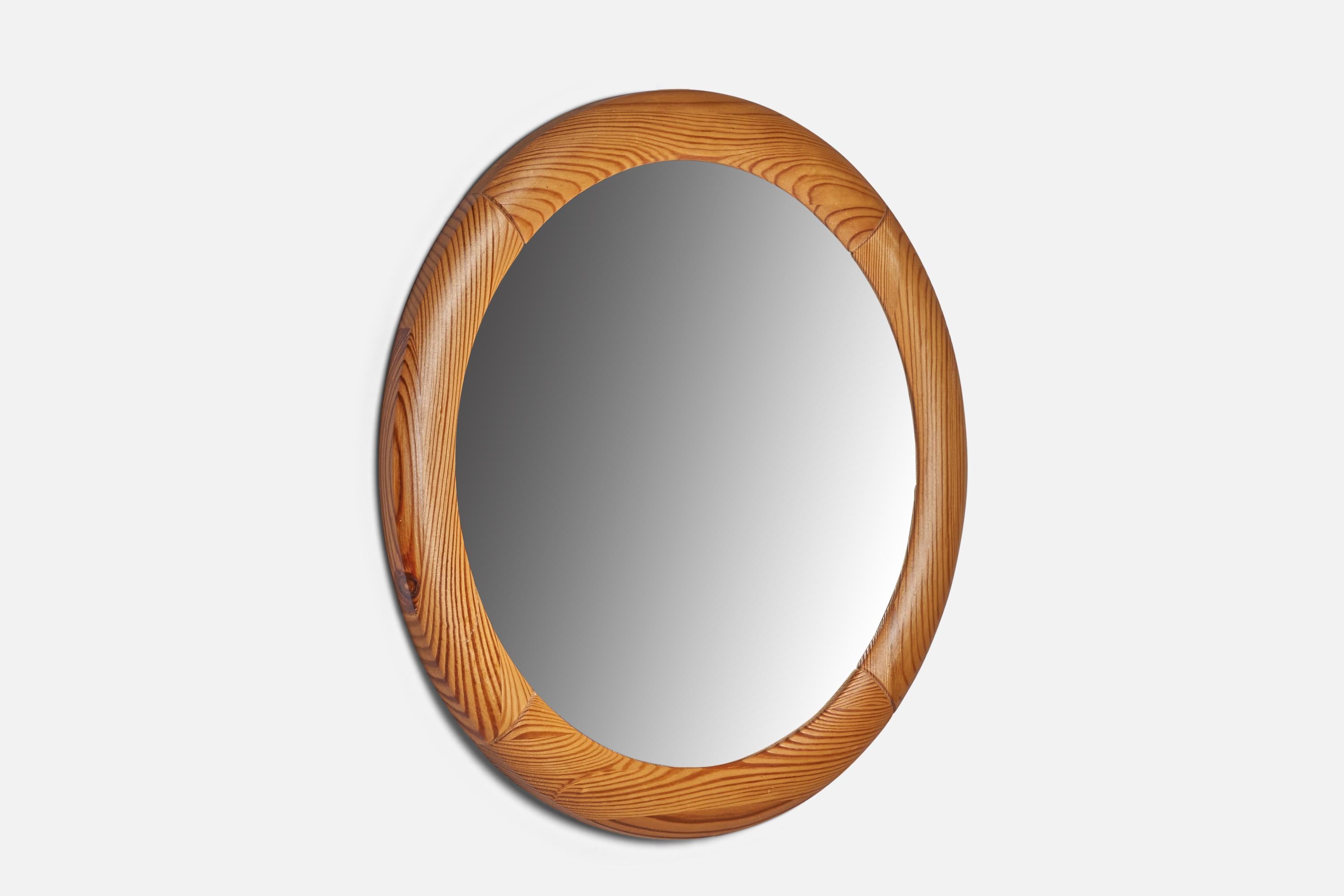 A round pine wall mirror designed and produced in Sweden, 1970s.