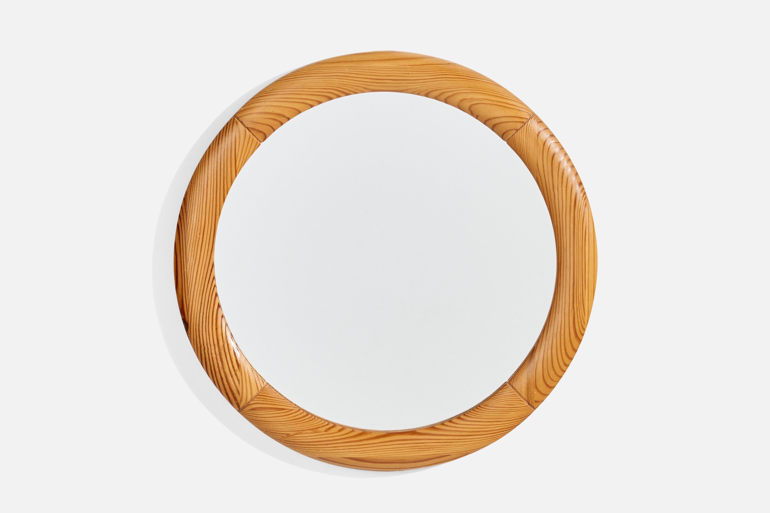 A round pine wall mirror designed and produced in Sweden, 1970s.