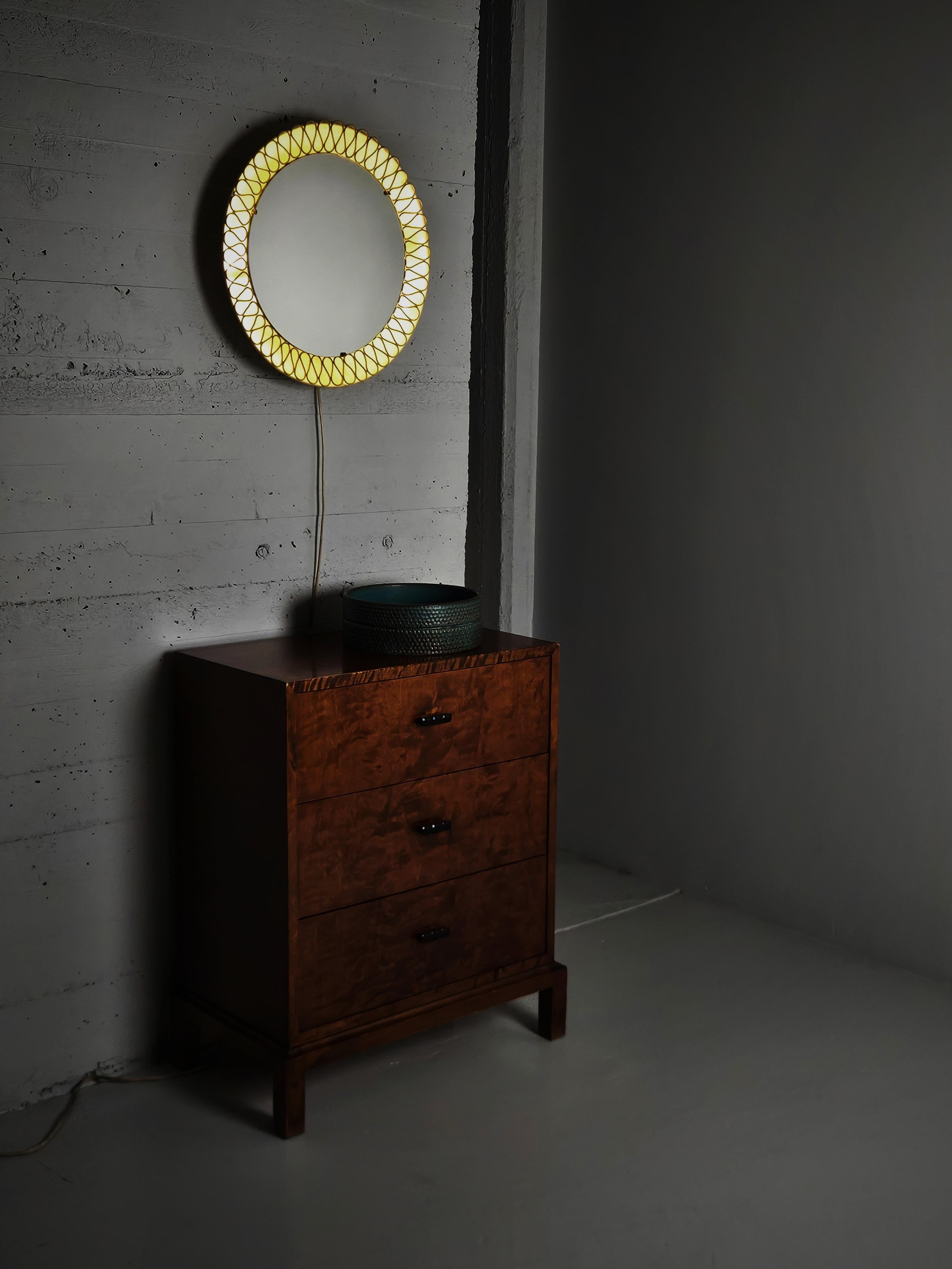 Miroir moderne suédois avec éclairage, milieu du 20e siècle.

Cadre rond en métal laqué avec motif percé. Deux sources lumineuses derrière le miroir.