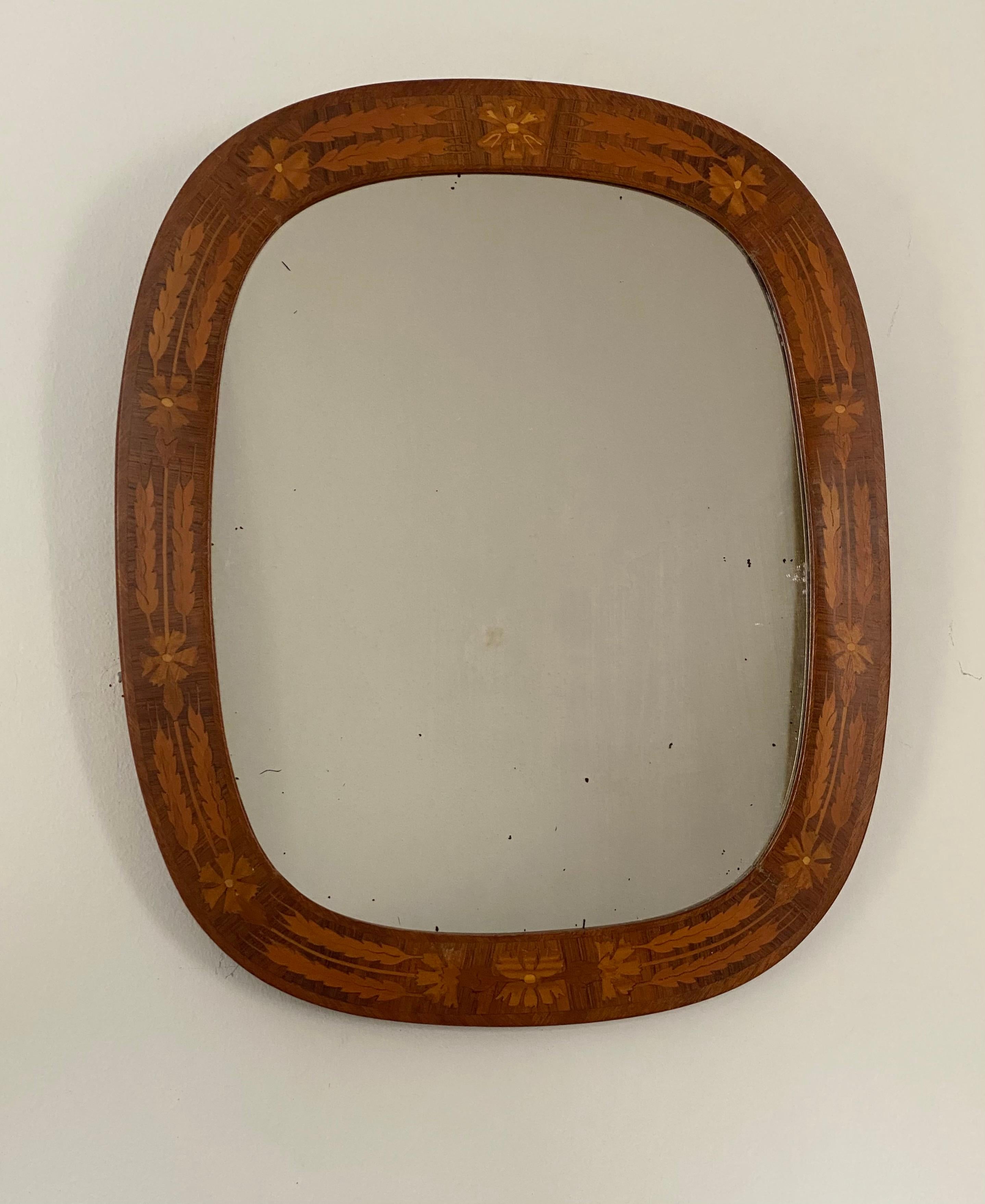 A wall mirror, designed and produced in Sweden, 1940s. Features a wooden frame with wooden inlays.

 