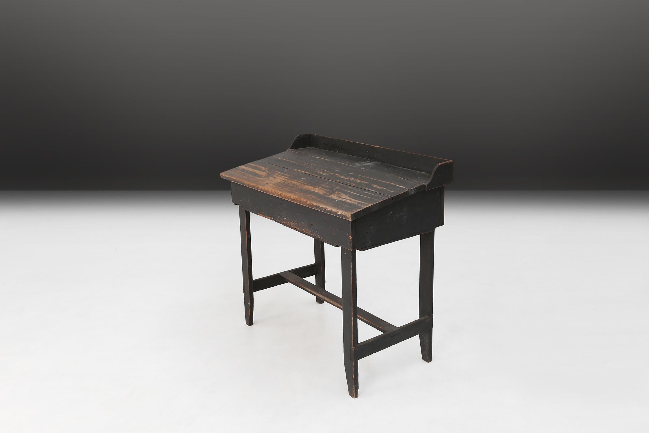 A rustic writing desk made during the 19th century in Sweden. Made of pine wood and original black paint. With great patina on the wood.