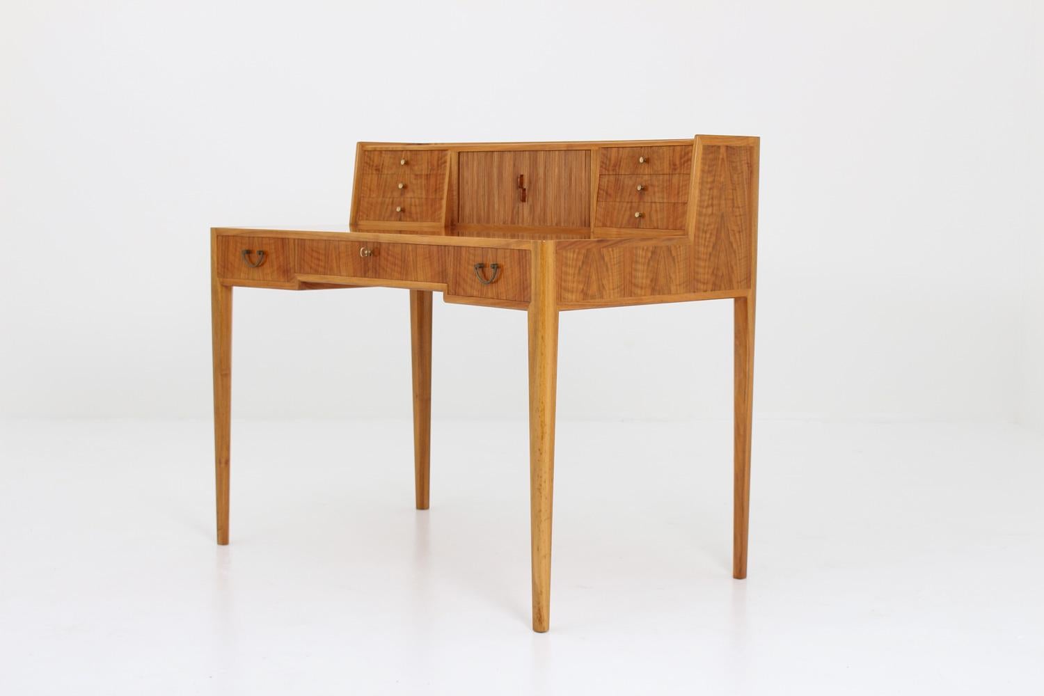 Incredible desk in Italian walnut by Swedish cabinet maker, circa 1960.
This studio craft desk is made with perfection in every detail. The desk is slightly rounded both at the front and the back. It features six small drawers and a jalousie on the