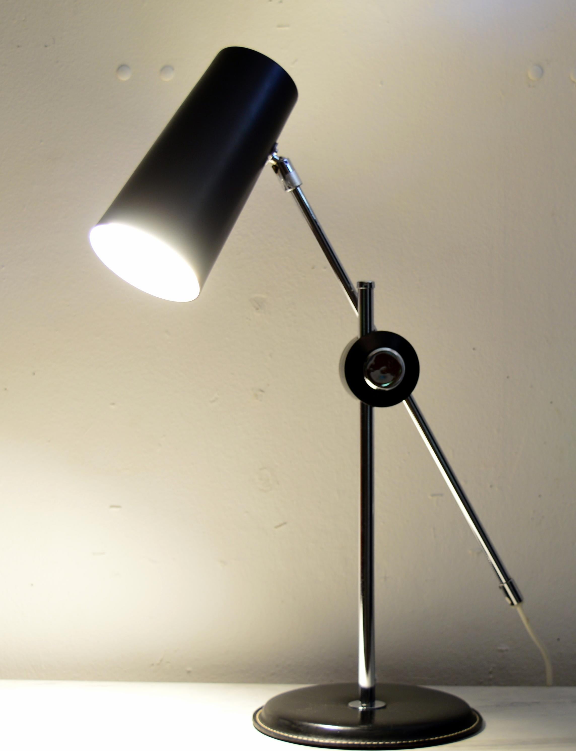 A rare Swedish mid century modern desk lamp with a black leather foot, chrome base and black lacquered metal shade. This 