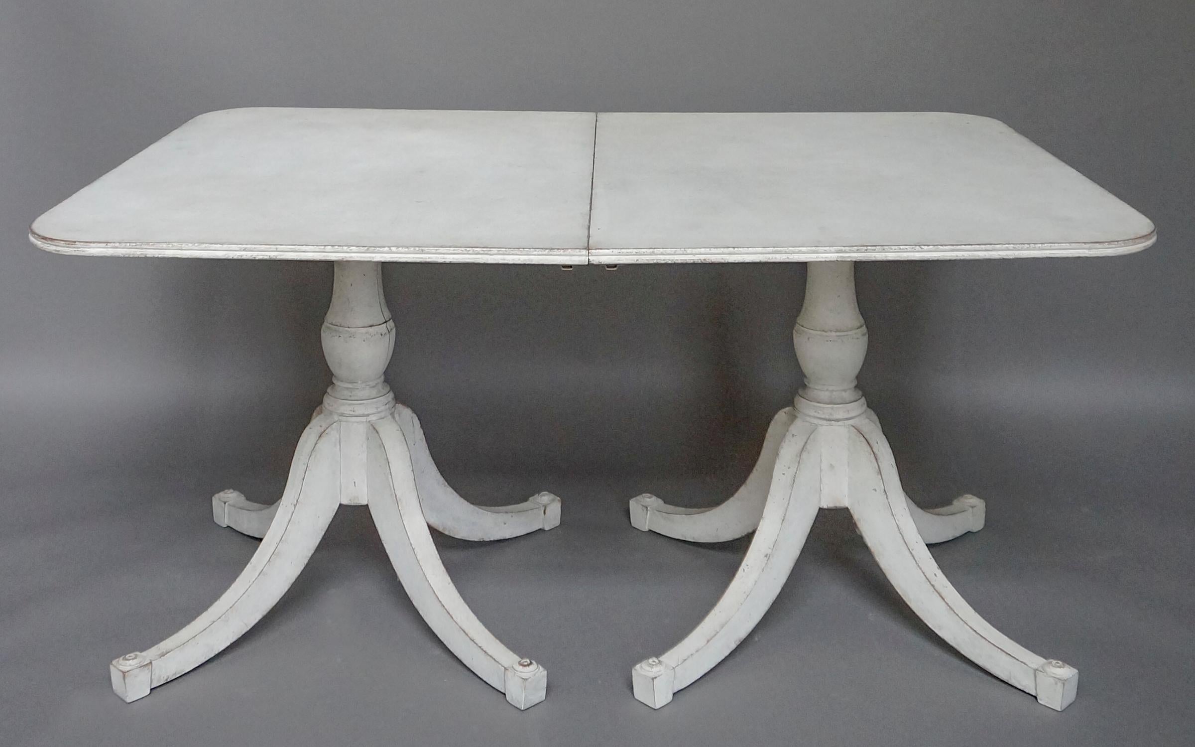Dining table, Sweden, circa 1860, composed of two connecting console tables. Pedestal bases with four curved legs, each finished with an applied roundel. A rare form.