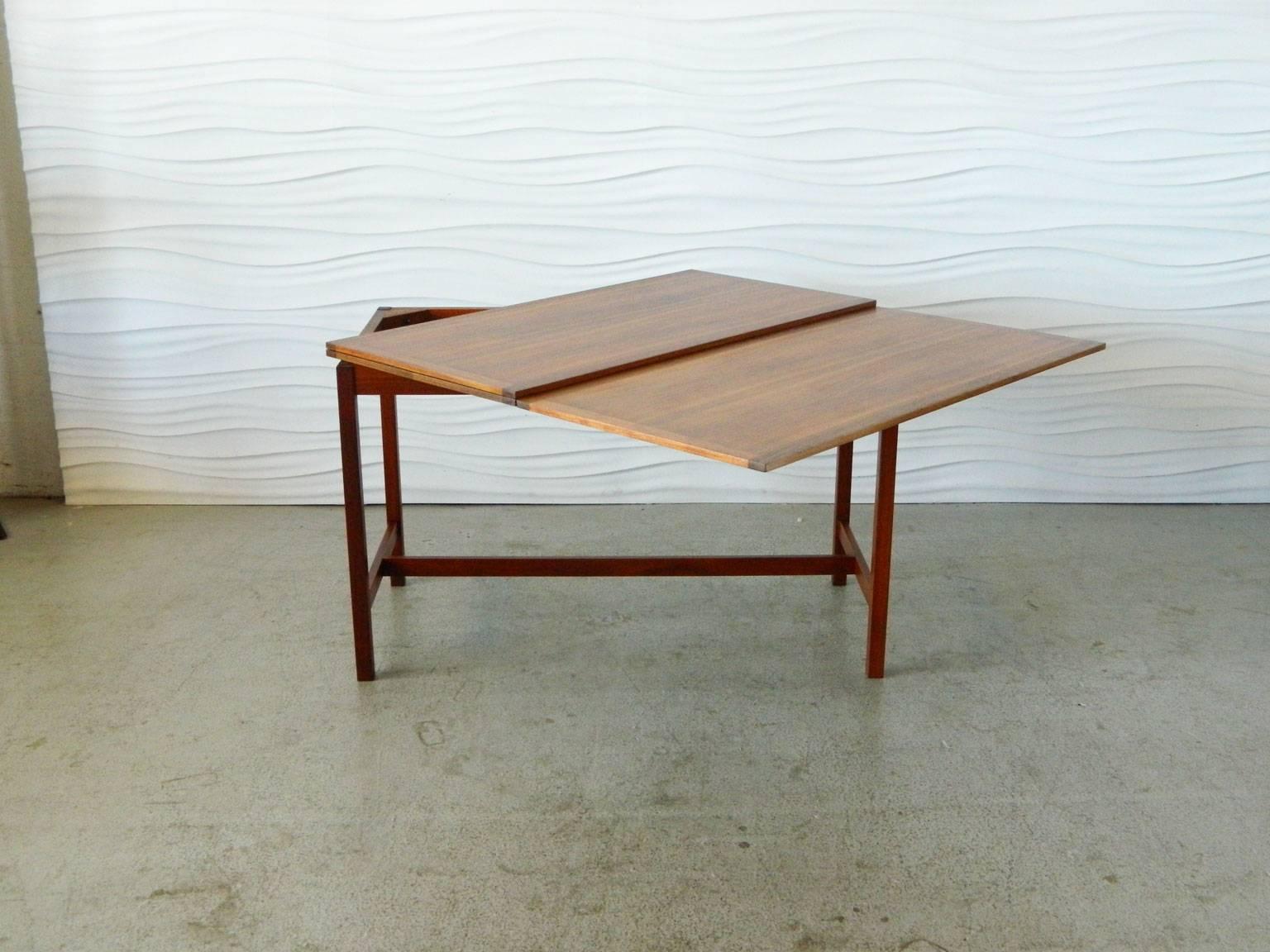 Designed by Karl Erik Ekselius, this drop-leaf table is made of walnut and has brass accents. It was manufactured by J.O. Carlsson. The table measures 66