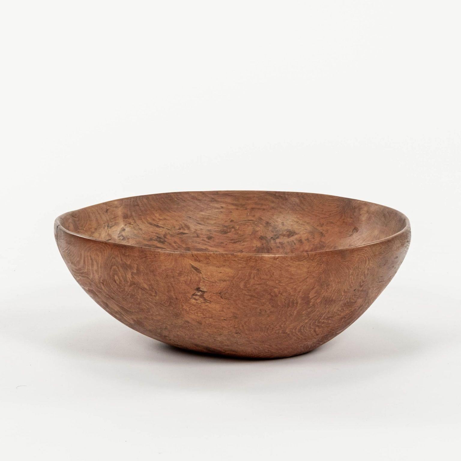 Organic slightly oval-shape Swedish dugout bowl covered in remnants of red paint. Burl root wood. Underside marked by maker 