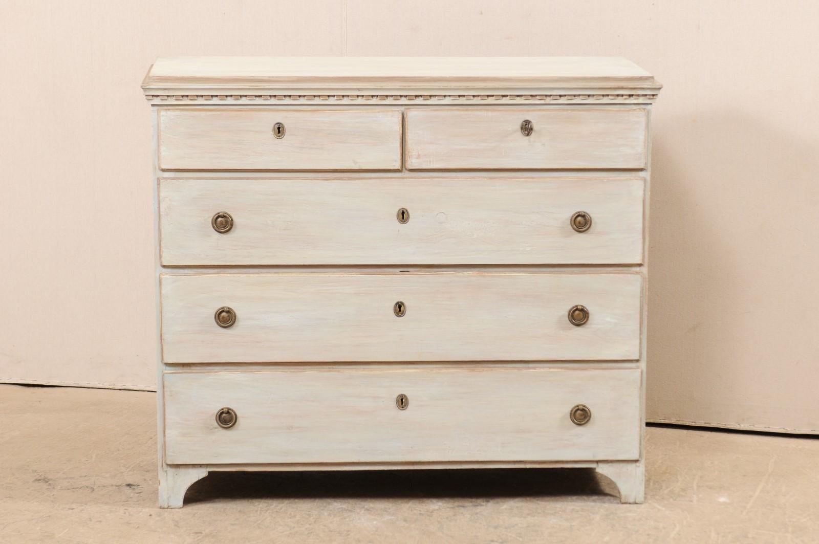 A Swedish chest of five dovetailed-drawers from the 1820s, just after the Gustavian period. This Swedish antique chest features clean, simple lines with lovely dentil trim just beneath the top ledge, and raised up on bracket feet. There are two