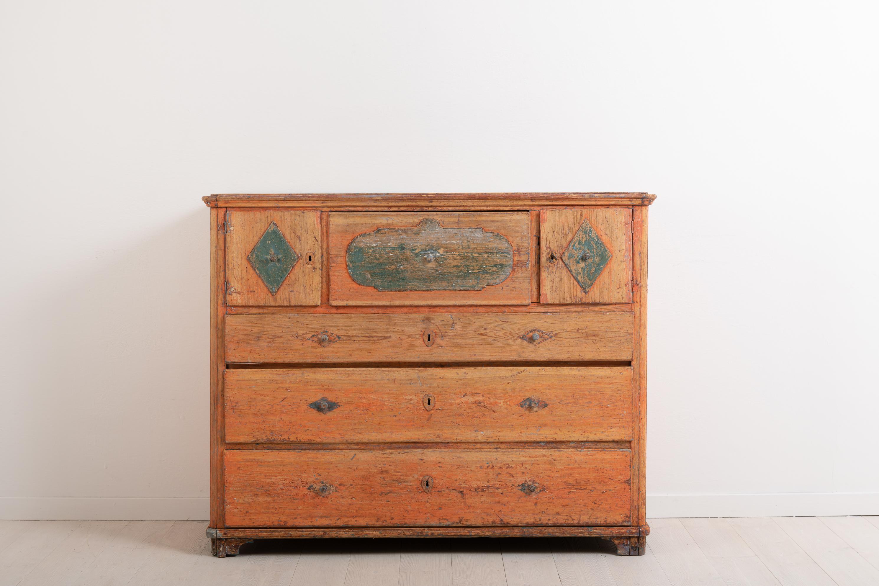 Swedish chest of drawers from the folk art period. This chest is from the early 19th century and has the original paint from the same time. While primitive it has some interesting details such as the doors on either side of the topmost drawer. All