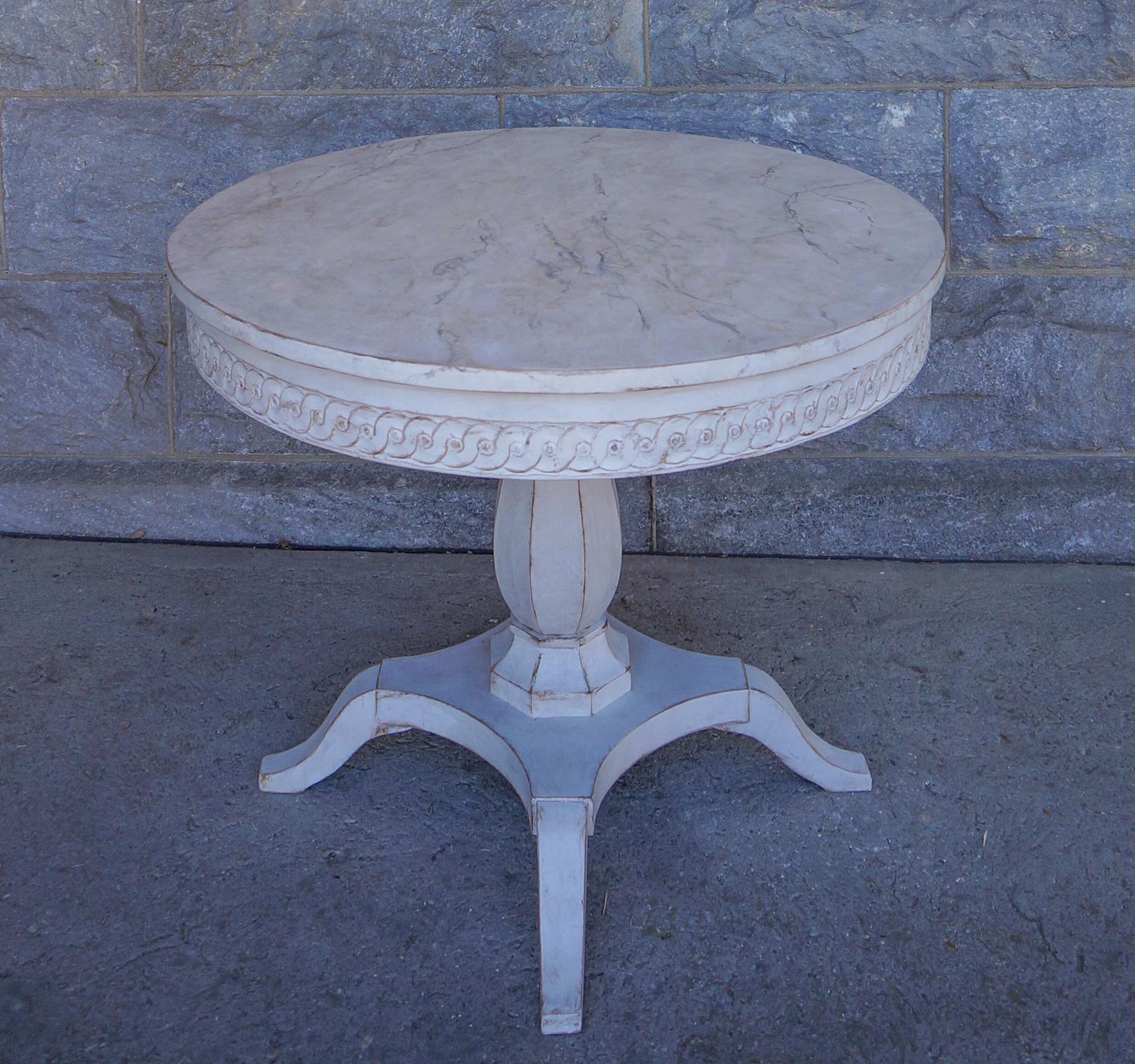 Period Empire center table, Sweden, circa 1840, with a circular top having guilloche carving around the apron. Faceted pedestal with bulbous form on a platform base with four curved feet.