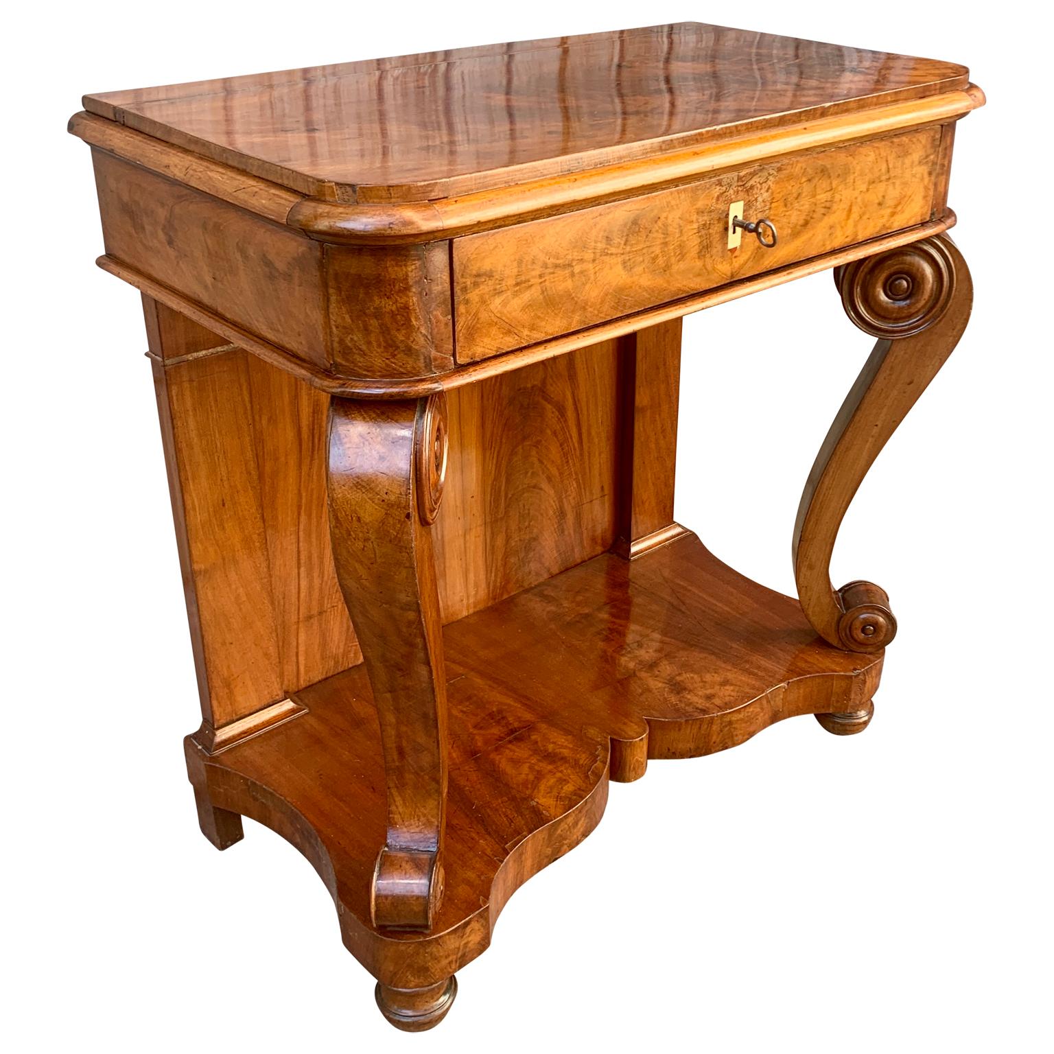 A Scandinavian mahogany early 19th Century Empire table or console. This antique Swedish Biedermeier piece has a drawer with its original working key included and a bottom shelf resting on rounded feet. It is probably made in the Baltic area of