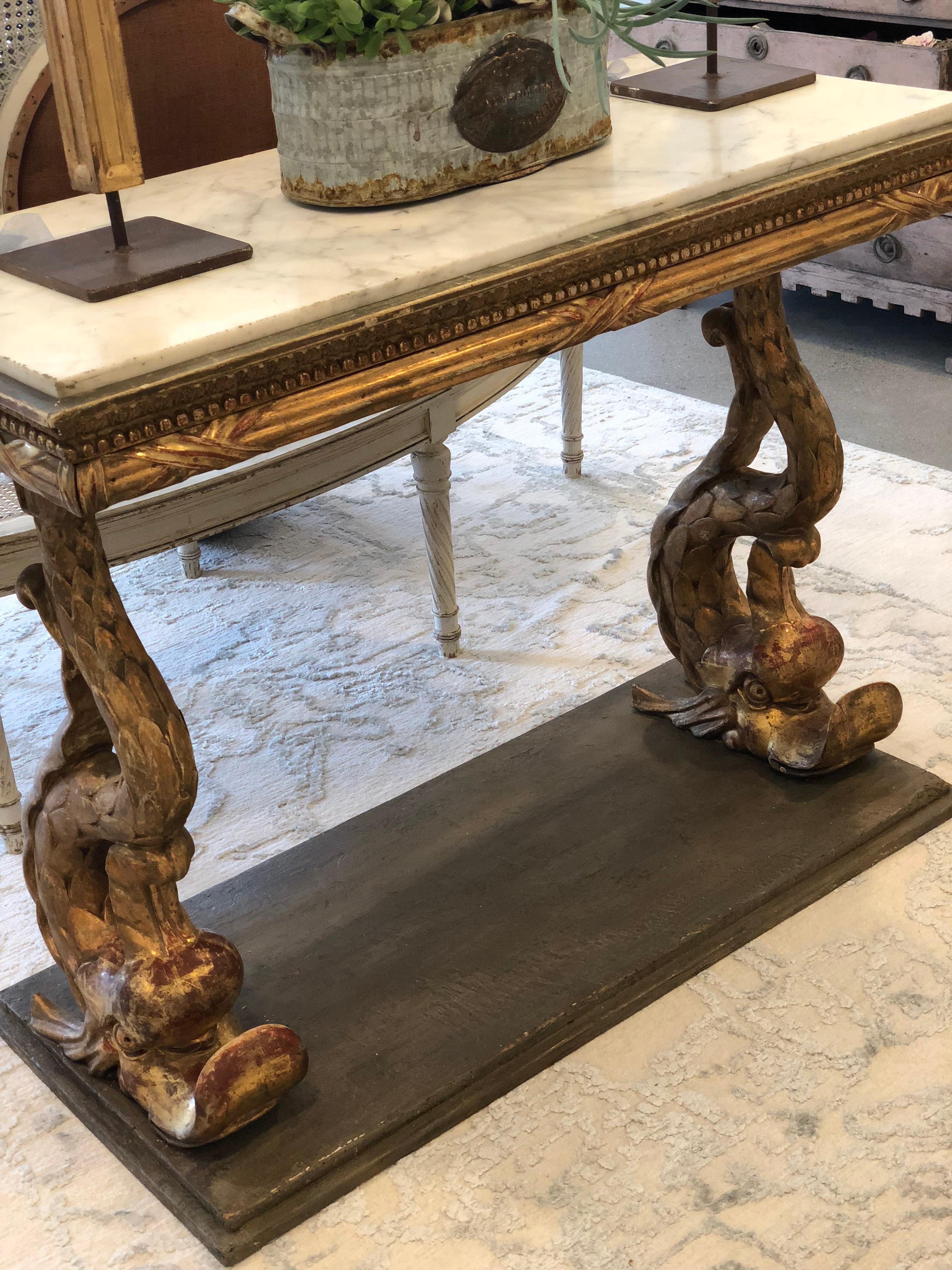 Highly decorative Swedish Empire period console with original marble top and gilt carved dolphin adorned legs. Later finished base.