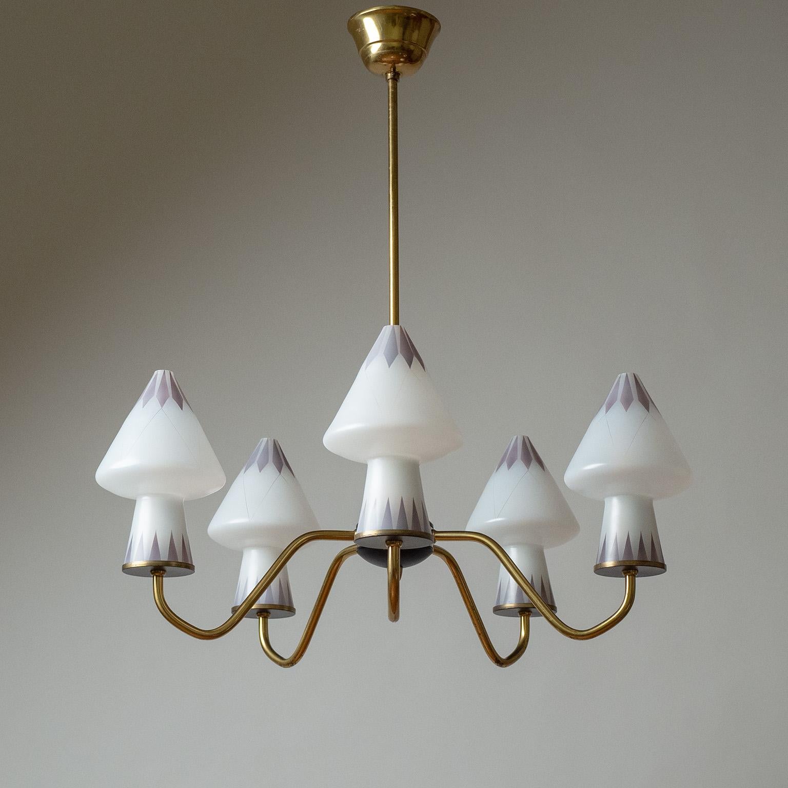 Sublime Sewdish brass chandelier from the 1950s with enameled glass diffusers. Five brass arms, each with a 'mushroom' shaped glass diffuser enameled in white and subdued purple. Very nice original condition with a light patina. Original bakelite