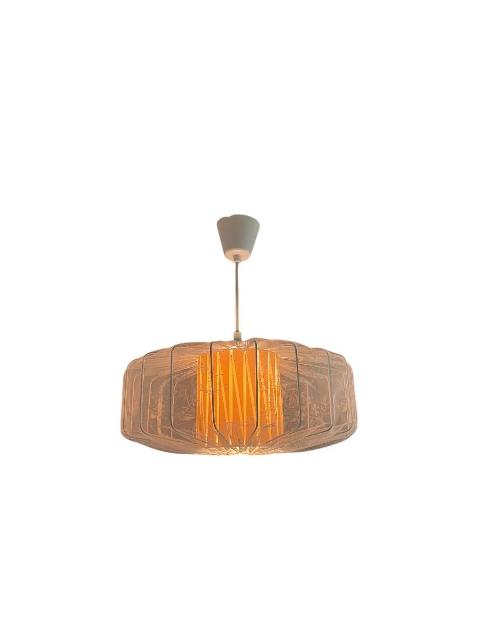 Encantadora lámpara colgante sueca de la década de 1940, con una delicada pantalla de tela tensada sobre un escultural armazón de metal. La suave luz difusa resalta los motivos florales bordados en el tejido transparente, creando un resplandor