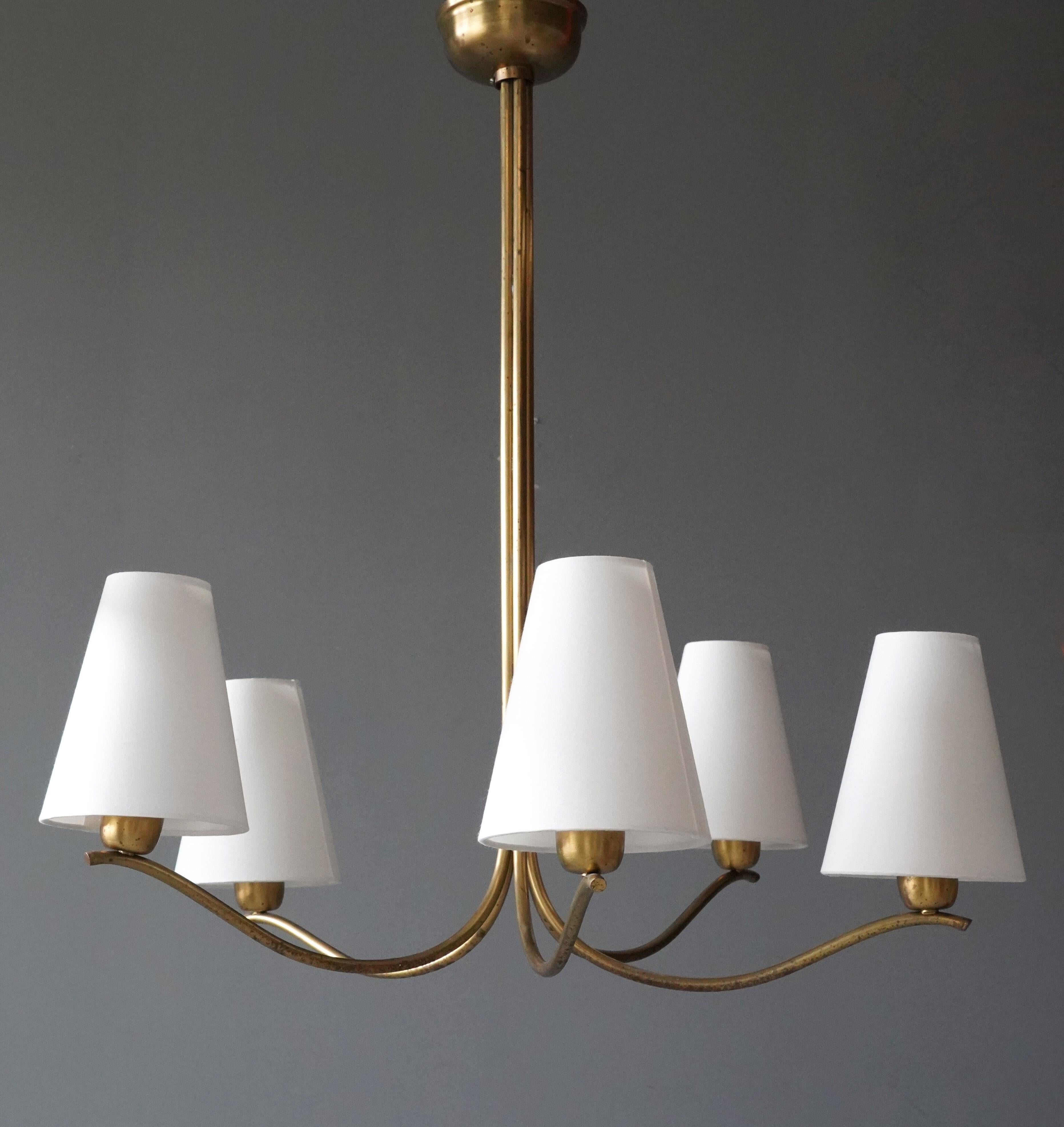 An organic five armed chandelier, designed and produced in Sweden, 1940s. 

Measurements are from the bottom of the fixture to the top of the escutcheon plate and diameter with illustrated shades mounted. 

Oxidation to brass throughout. Please