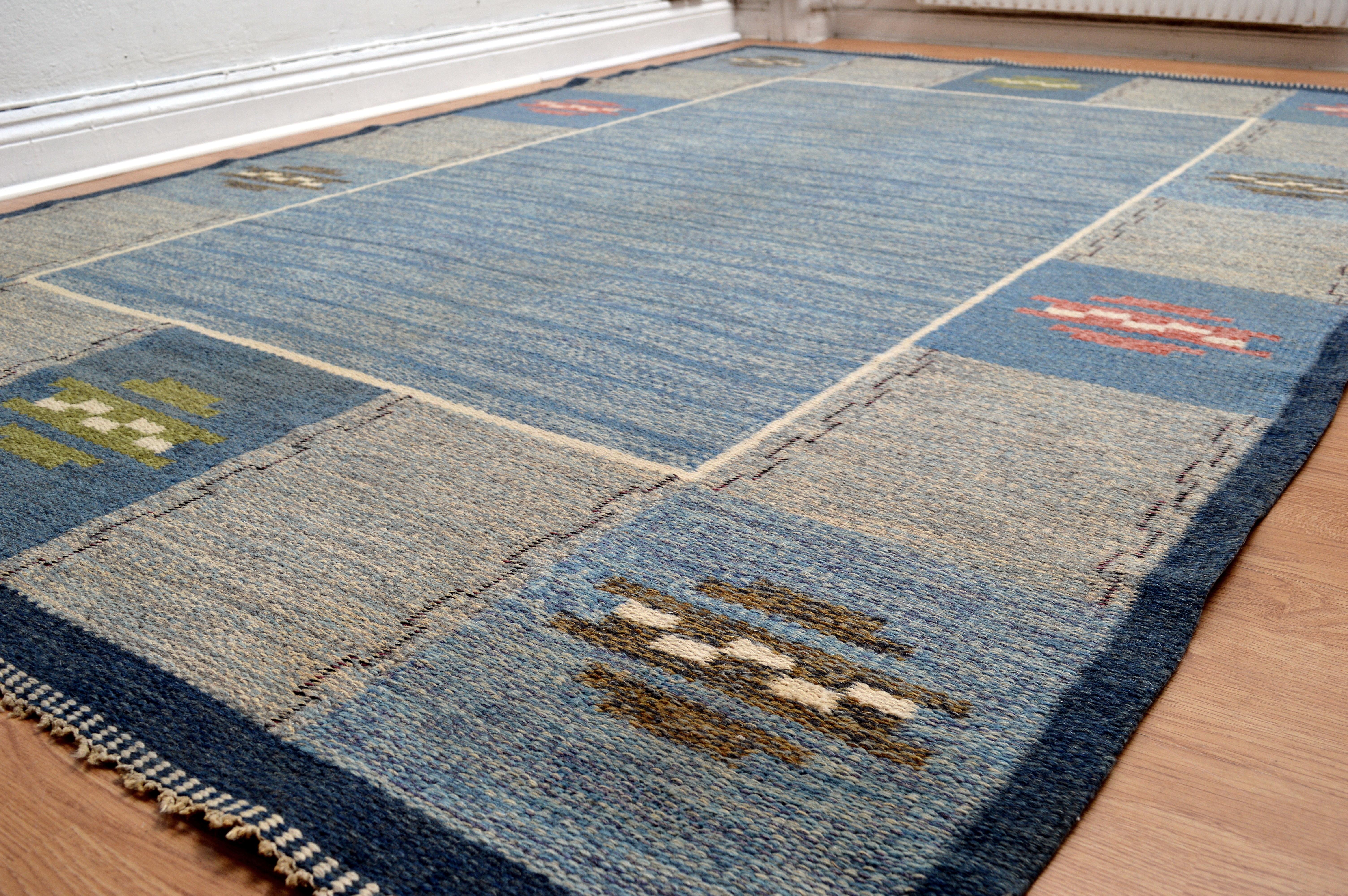 Vintage Swedish Flat Woven Rug attributed to Rakel Carlander (Size: 244 cm x 163 cm). Color: Blue, Beige, Grey, Pink, Green and White. A vintage Swedish hand woven wool rug in flat weave rölakan technique, It is a collectible piece in good original