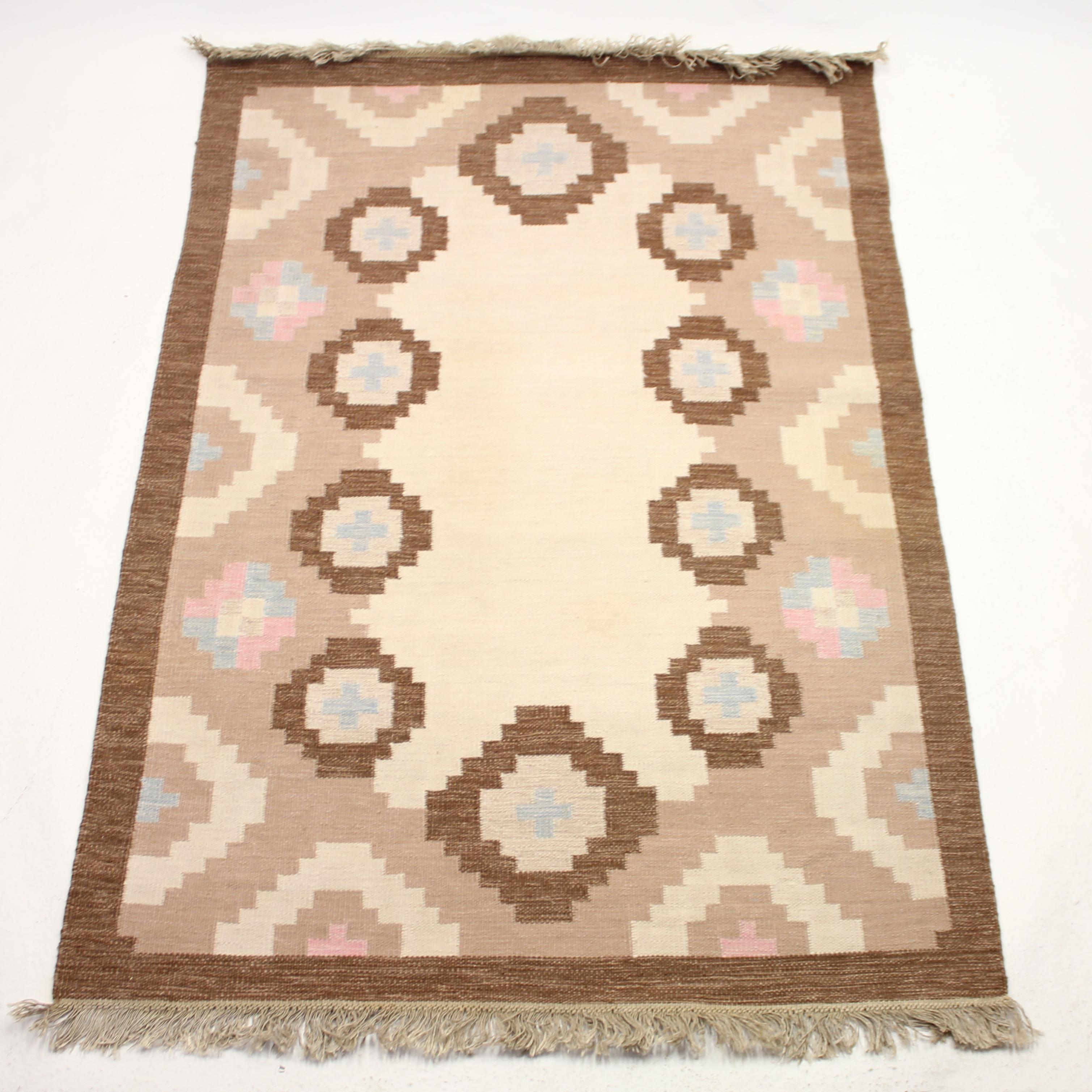 Swedish flat weave Röllakan carpet from the 1950s by unknown designer. Main colour is brown in a few different tones with a variety of patterns and shapes in beige, blue, pink on a brown/beige bottom/base. Newly cleaned by a professional carpet