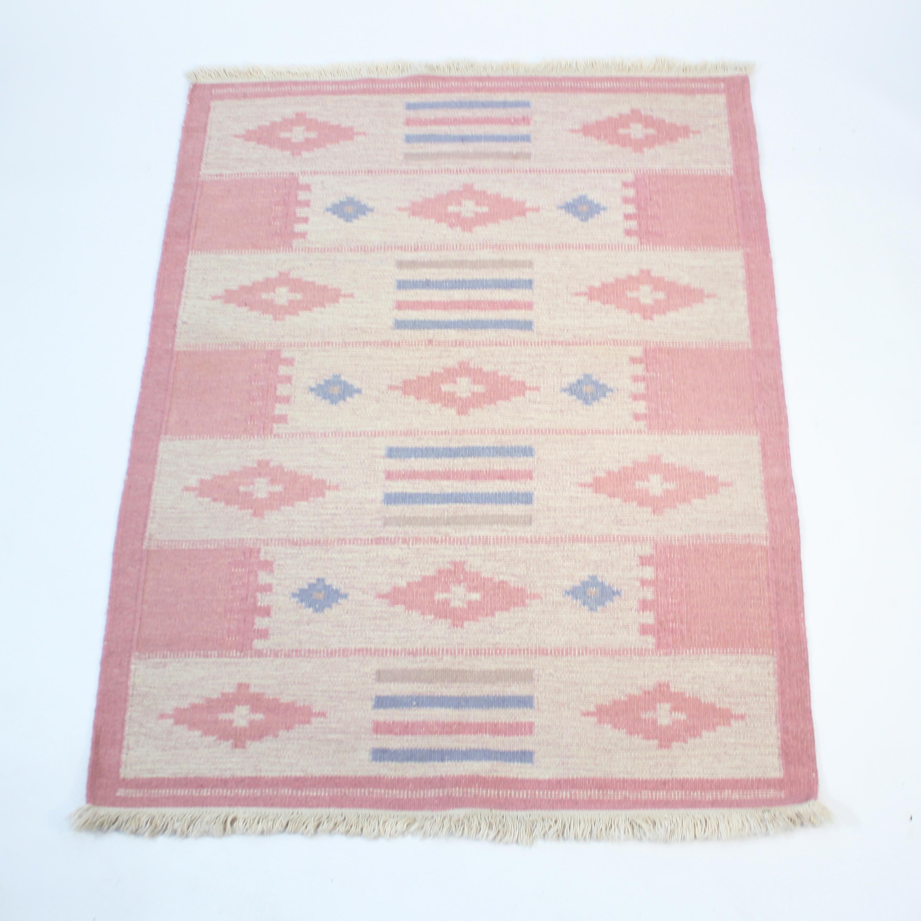 Tappeto svedese a trama piatta Röllakan degli anni '1960 di designer sconosciuto. I colori principali sono il marrone/beige in diverse tonalità. Il motivo è composto da una cornice rosa chiaro e da forme diverse in rosa, blu e grigio su un