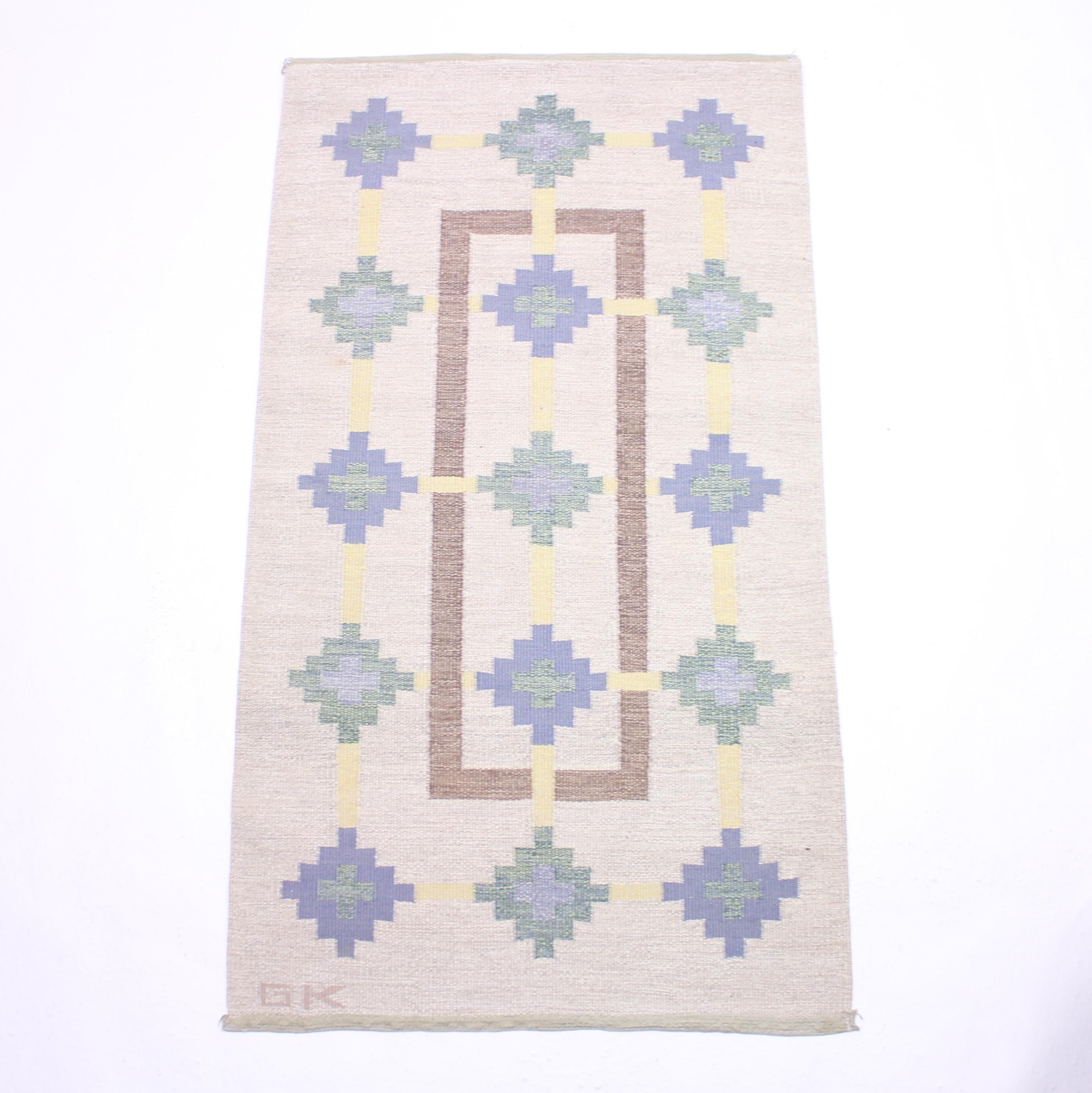 Swedish flat weave Röllakan carpet signed GK by unknown designer from the 1950s. Main colours are off-white with a dose of green, blue yellow and brown. Newly cleaned by a professional carpet cleaning company. Very good vintage condition with