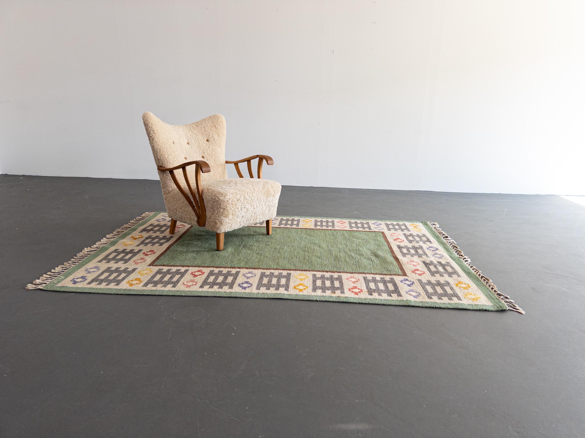 Un magnifique et rare tapis vintage à tissage plat conçu par l'artiste textile suédoise Anna Wengholm au milieu du 20e siècle. Ce tapis rölakan fabriqué à la main est un exemple frappant du folk-modernisme suédois, mêlant précision géométrique et