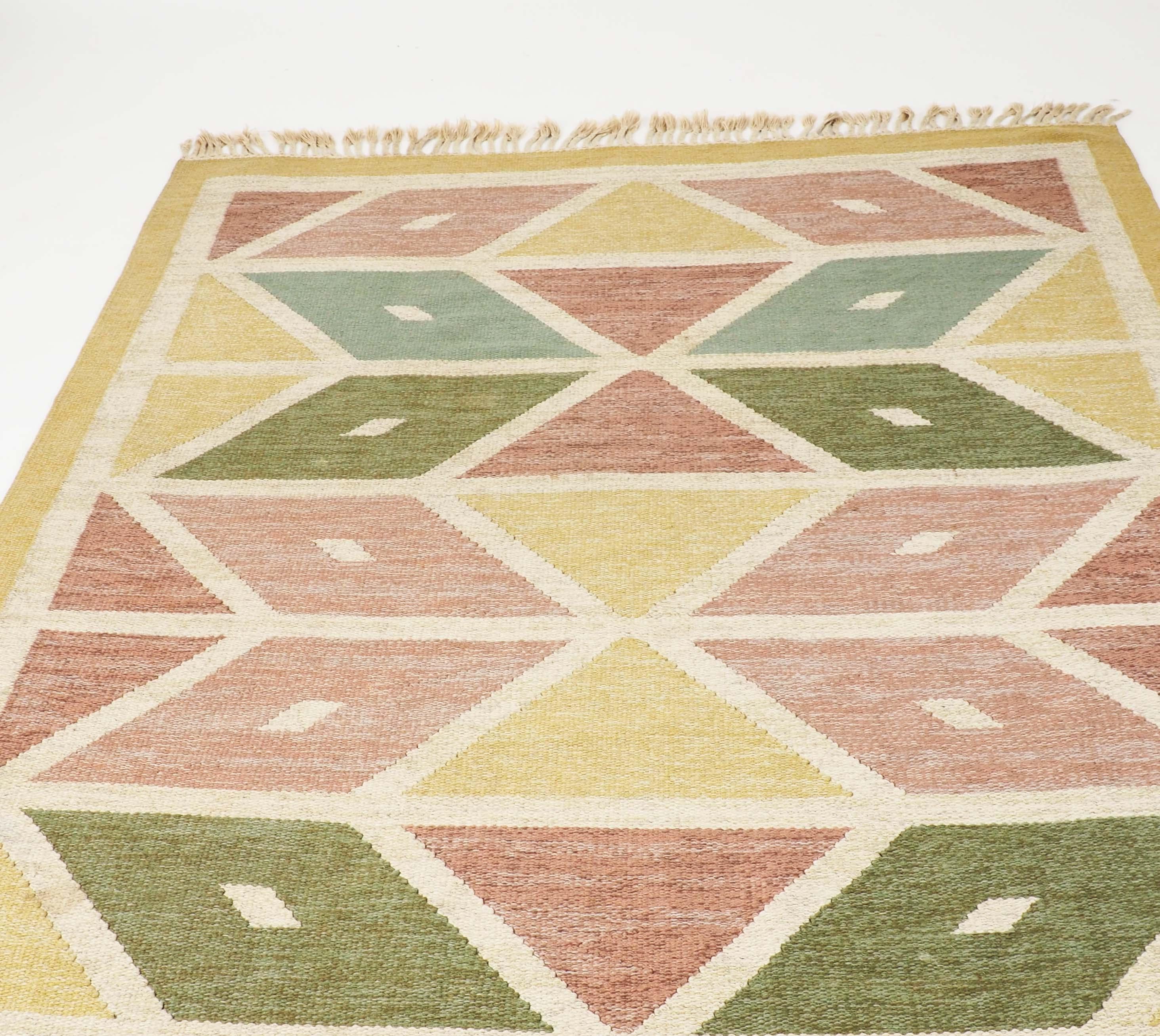 Swedish flat-woven rug in wool. Handmade in the 1950s and signed IB by the artist. Diamond shaped pattern in a strict geometrical design.
      
