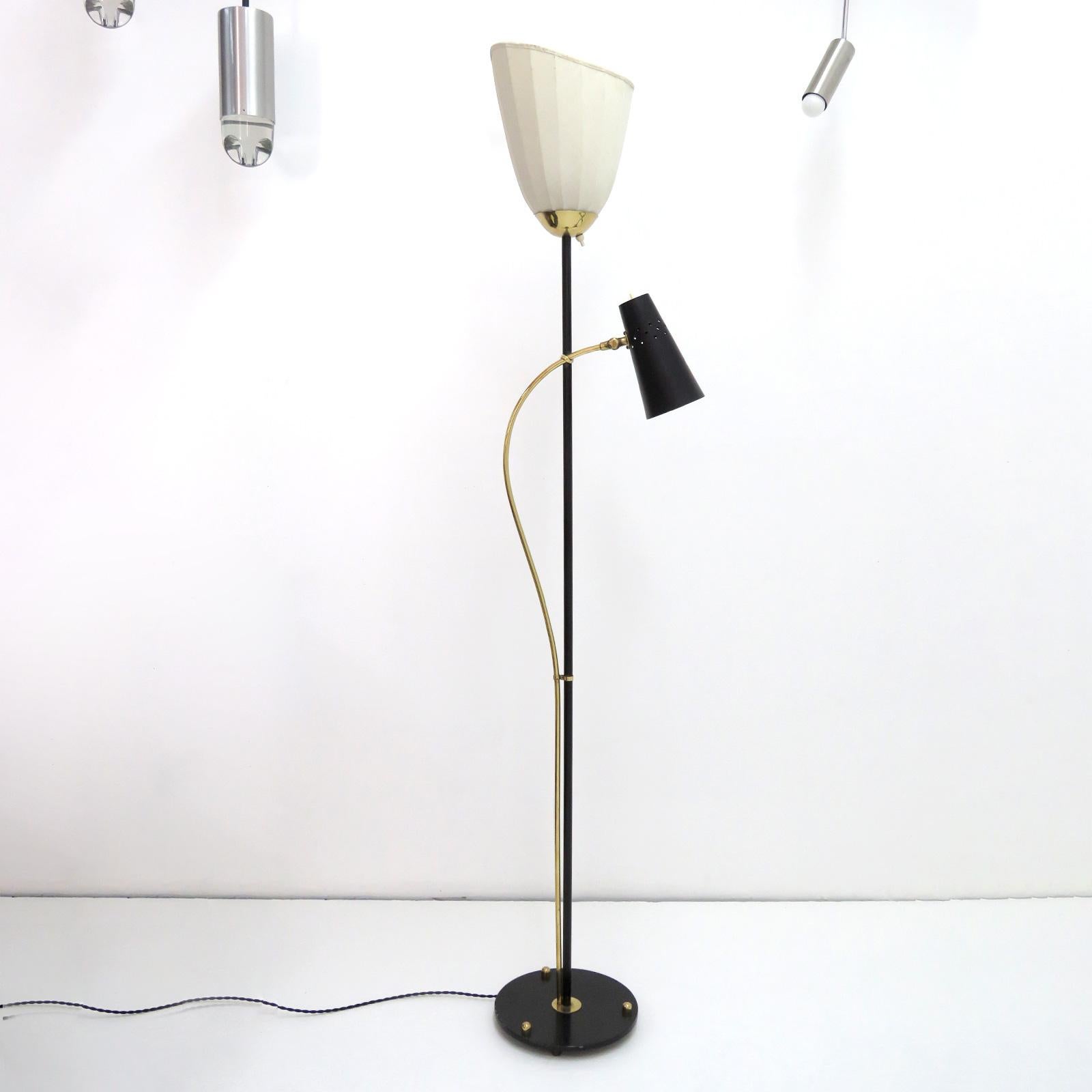 Rare 1950s Swedish double-arm floor lamp by Hans Bergström for Ateljé´ Lyktan in Åhus, Sweden, with one standing light with a fabric cocoon shade and a black enameled metal cone down-light with small perforations to the shade, individual on/off