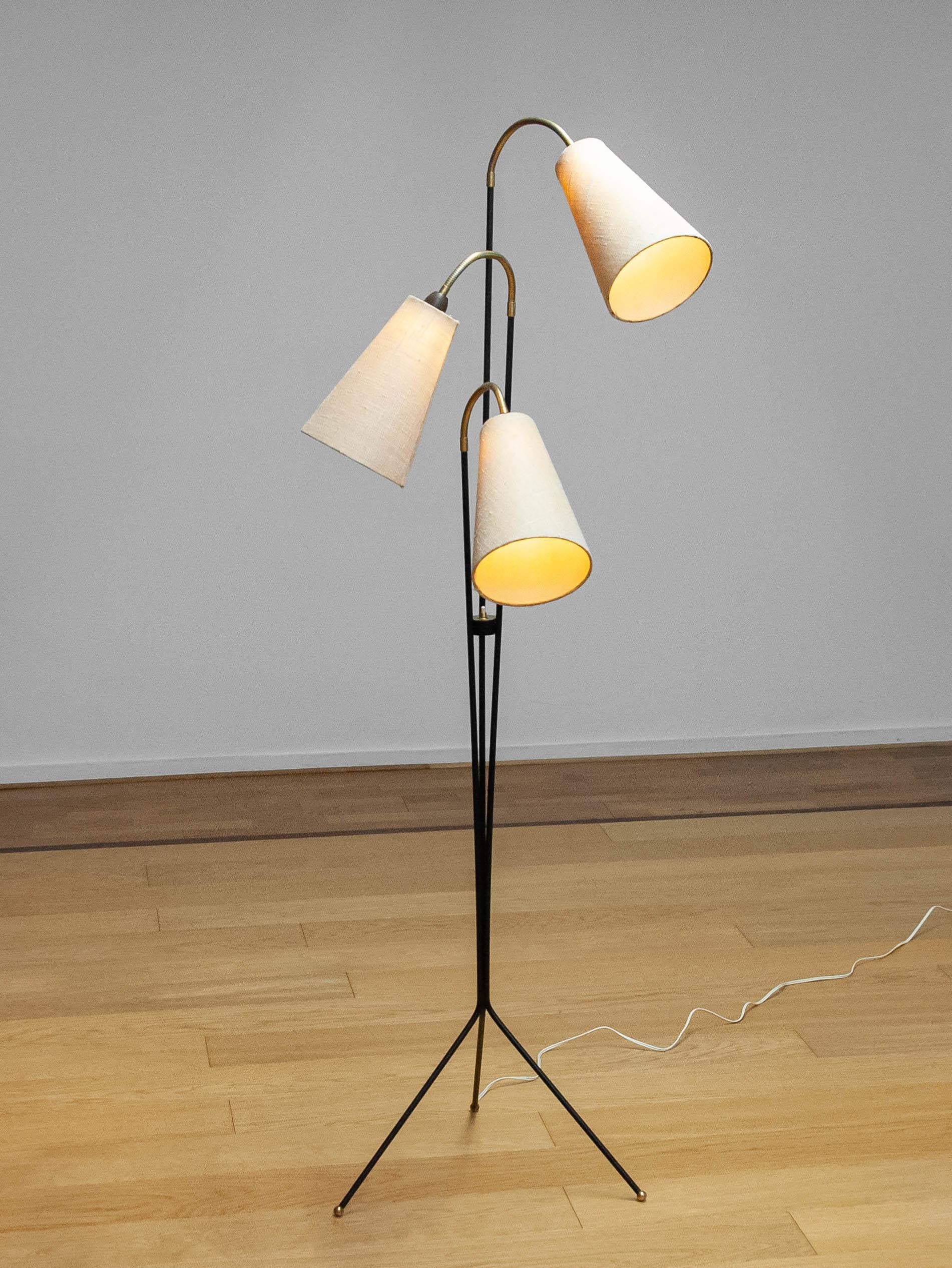 Impressionnant et original lampadaire suédois en métal laqué noir avec des détails en laiton et en bakélite conçu par Svend Aage Holm Sørensen.
Ce luminaire contient trois douilles à vis (taille E27) et trois abat-jours originaux en jute.
La lampe