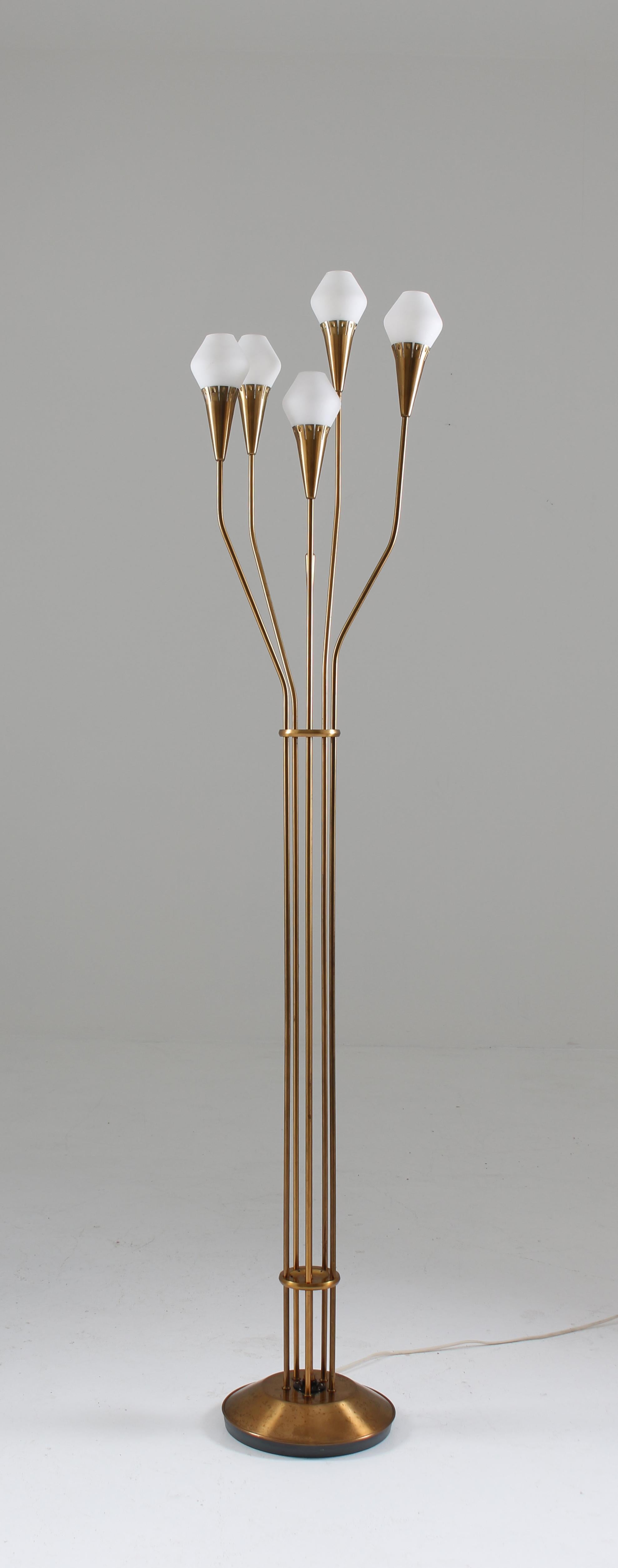 Extremely rare floor lamp in brass and opaline glass by Böhlmarks, Sweden. 
This top-quality floor lamp consists of five light sources, each on a separate brass pole, holding a shade in opaline glass. The light switch is the brass rod in the