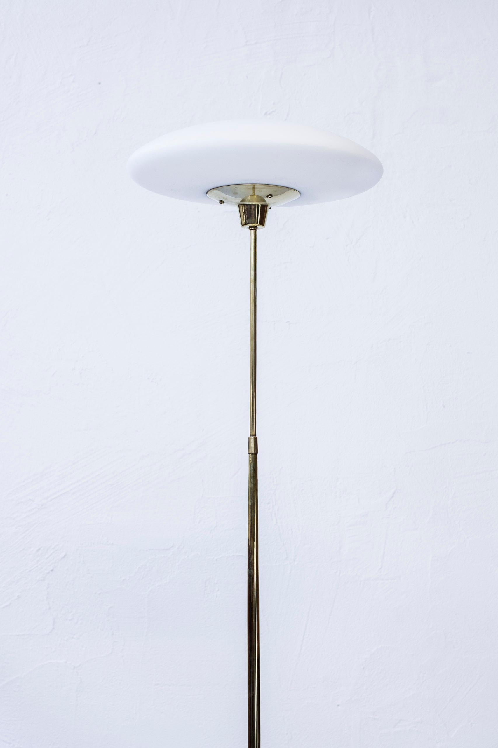 Floor lamp produced in Sweden by ASEA Belysning. Done sometime during the 1950s. Made from solid polished brass with opaline glass shade. Light switch on the chord. Excellent condition with few signs of wear and patina.
 