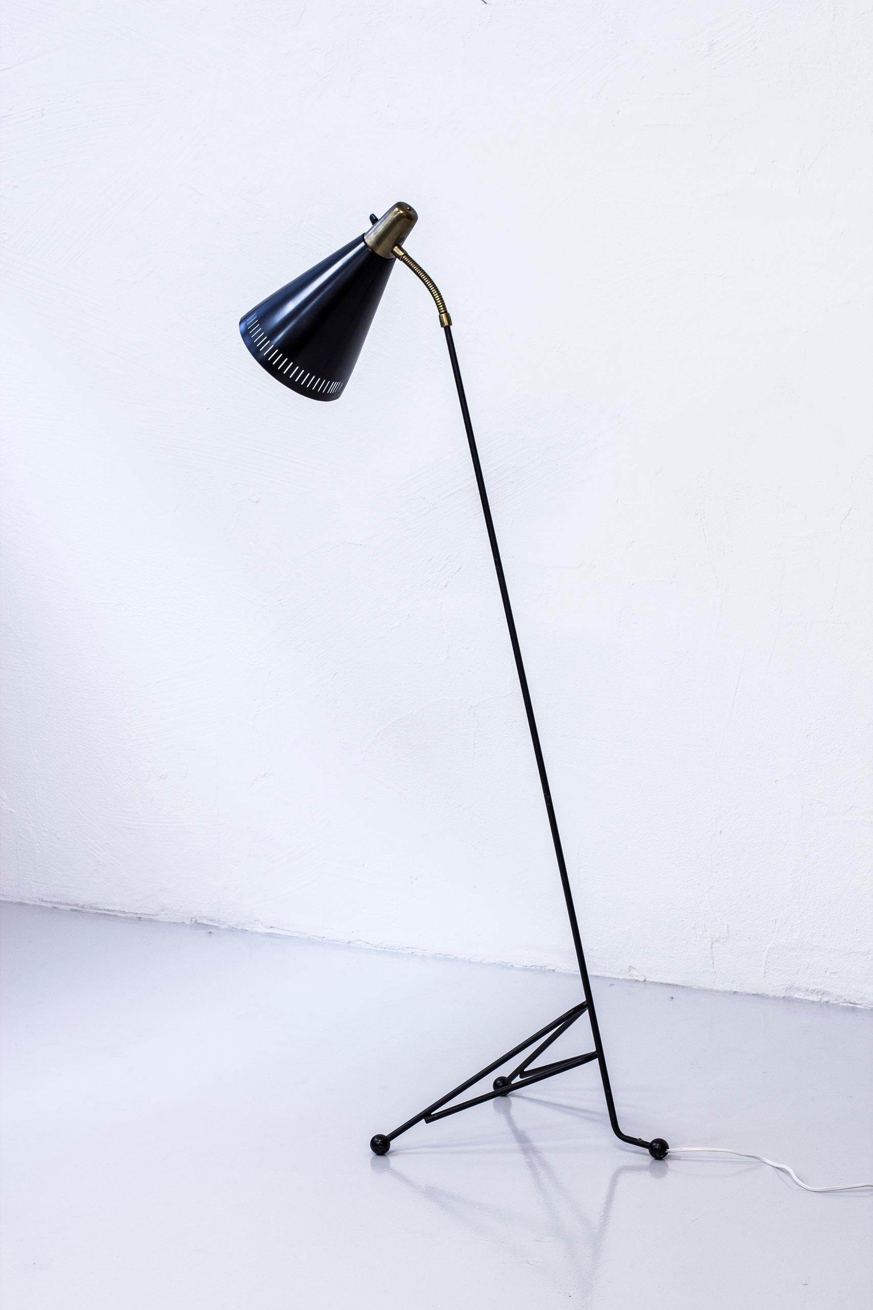 Floor lamp produced by Eskilstuna Armaturer in Sweden during the 1950s. Model no 144. Made from black lacquered metal with aluminum shade and brass details. Large oversized ball feet. Original light switch on the light fixture. Excellent condition