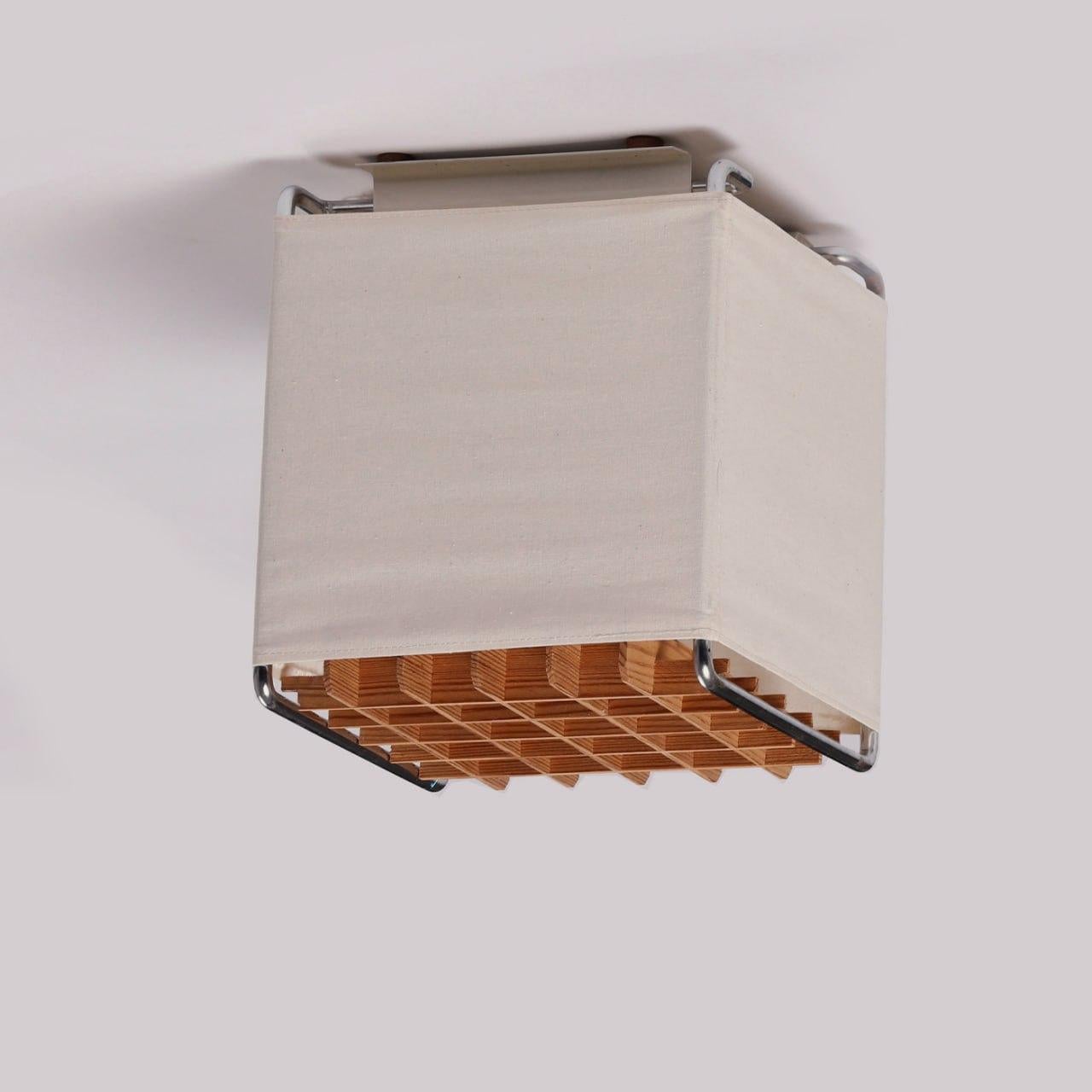 Swedish mid-century modern flush-mount ceiling lamp, produced in the 1970s. Metal frame, original semi-transparent fabric, removable wooden grid. The lamp is equipped for one light bulb. In good original condition, wear consistent with