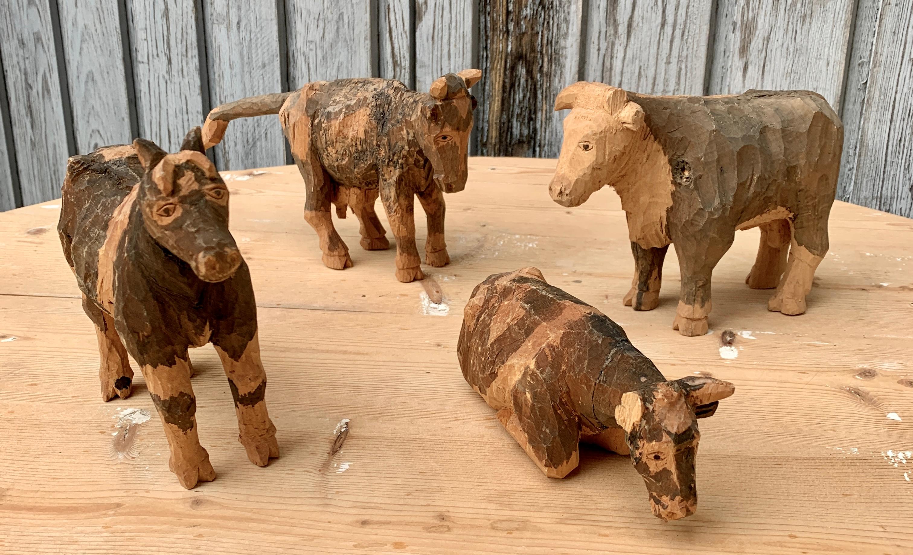 Ensemble suédois de quatre figurines en bois sculpté et peint représentant un taureau et trois vaches, datant du début du XXe siècle. La Suède a une longue tradition bien connue de sculpture en bois d'art populaire. Cela a commencé dans la classe