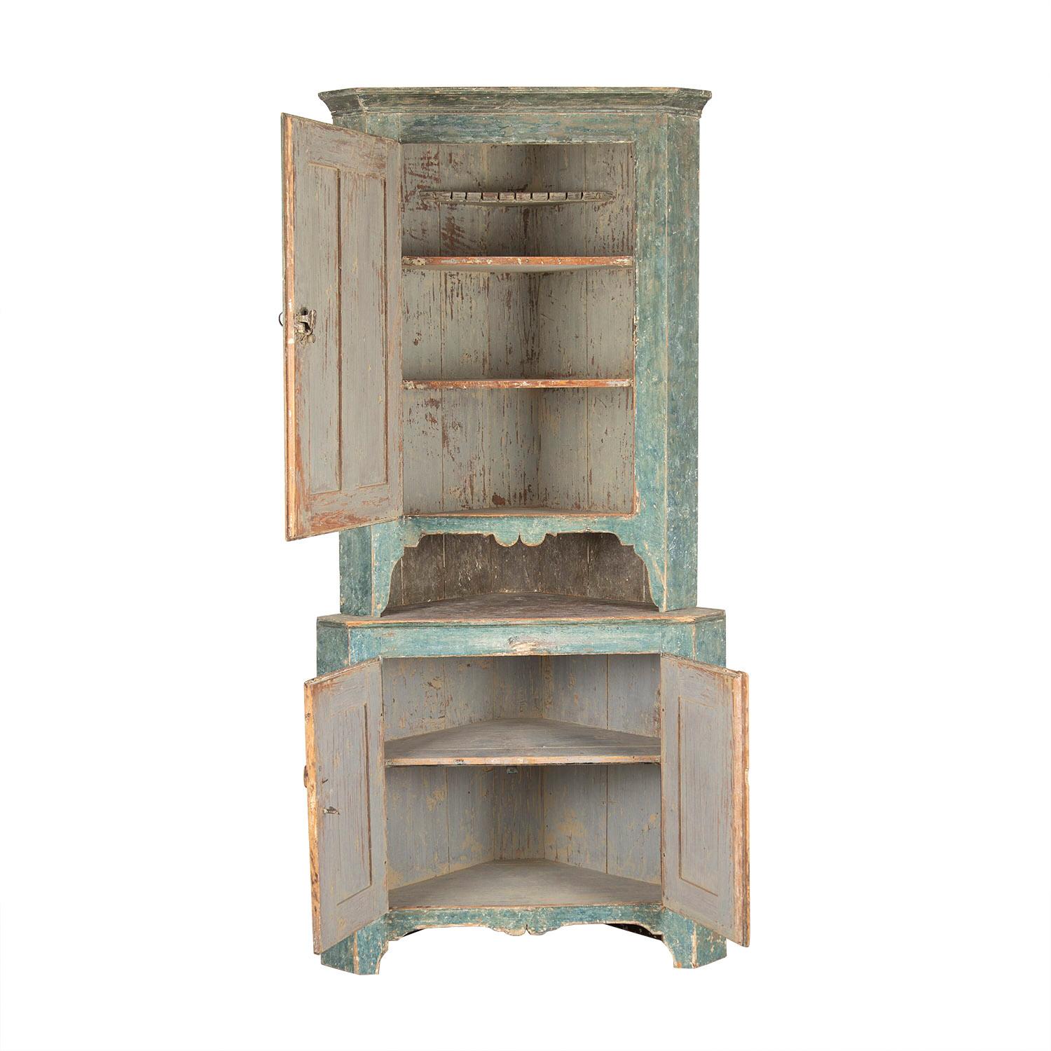 Folk Art corner cabinet from the region of Narke. This piece has original paint colour both inside and out. A large single carved front door opens to storage, below two further carved doors open to further storage.